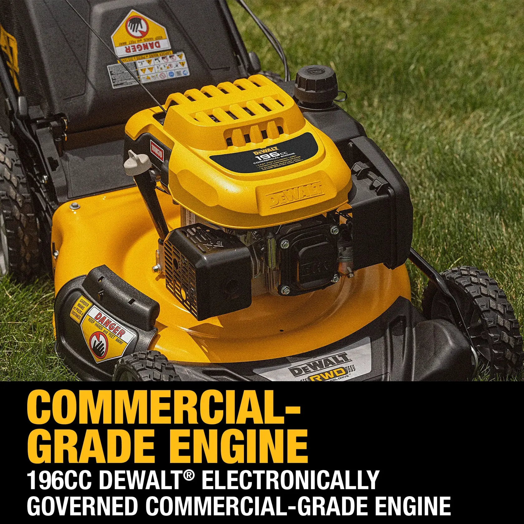 Close-up of a DEWALT lawn mower featuring a 196cc electronically governed commercial-grade engine. The mower is yellow and black, positioned on green grass, with warning labels visible on the machine.