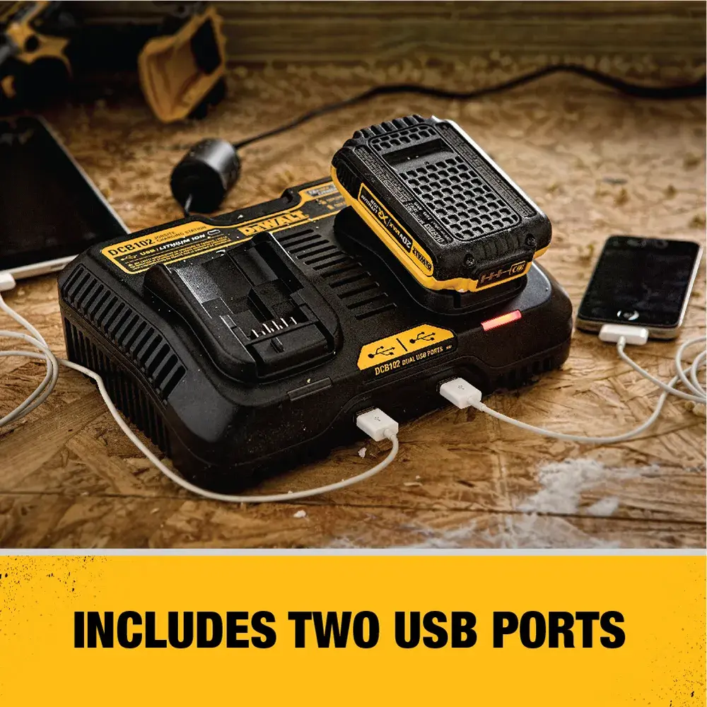 A DEWALT battery charger with two USB ports, charging a battery and two electronic devices on a wooden surface. Text reads: 'Includes two USB ports.'