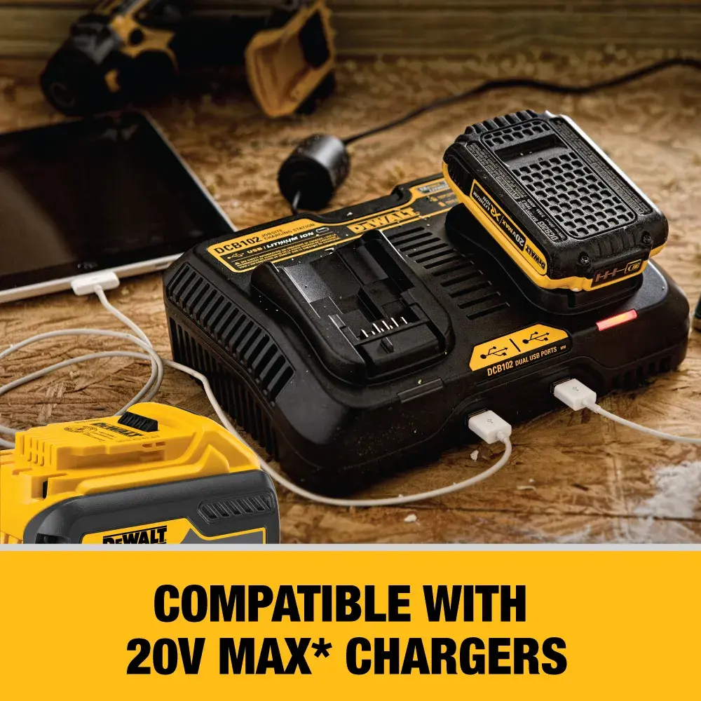 A DEWALT battery charger with a battery placed on top, two USB devices connected, and text indicating compatibility with 20V MAX chargers. The charger and battery are on a wooden surface.