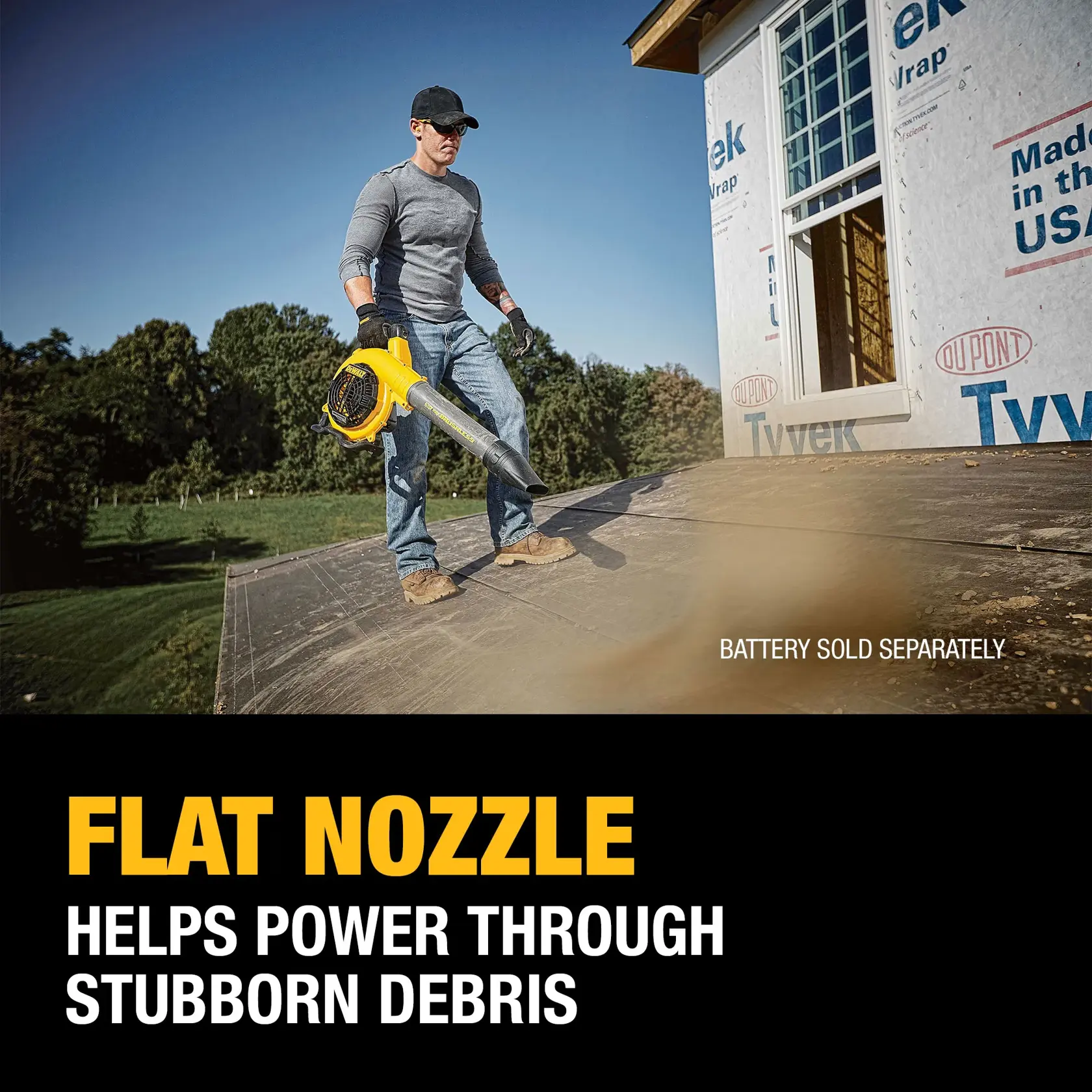 A person stands on a roof using a DEWALT blower with a flat nozzle, clearing persistent debris. The text highlights that the flat nozzle helps power through stubborn debris and notes that the battery is sold separately.