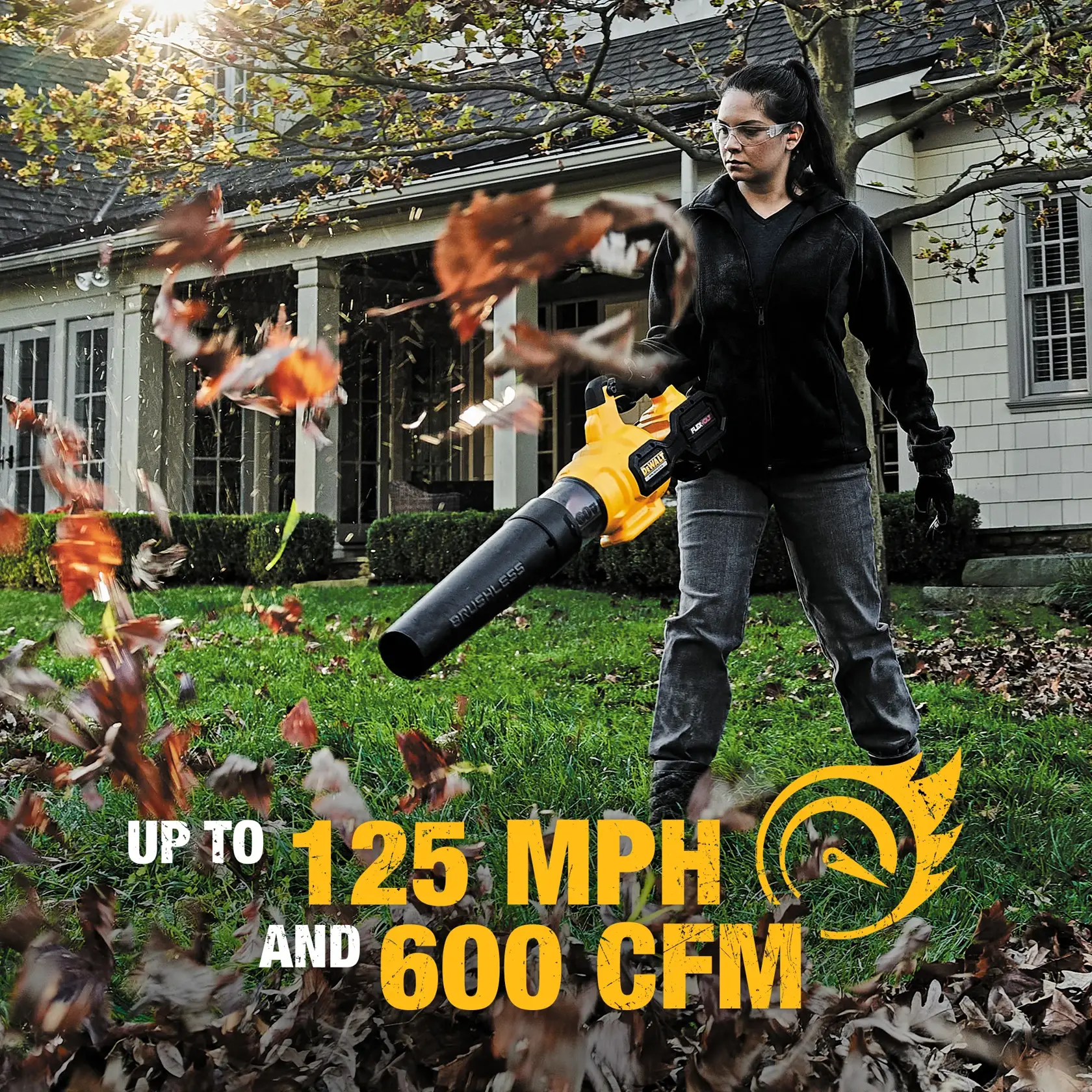A person using a DEWALT handheld leaf blower in a yard, blowing autumn leaves. The device is yellow and black, and text on the image reads 'Up to 125 MPH and 600 CFM'. A house and trees are visible in the background.