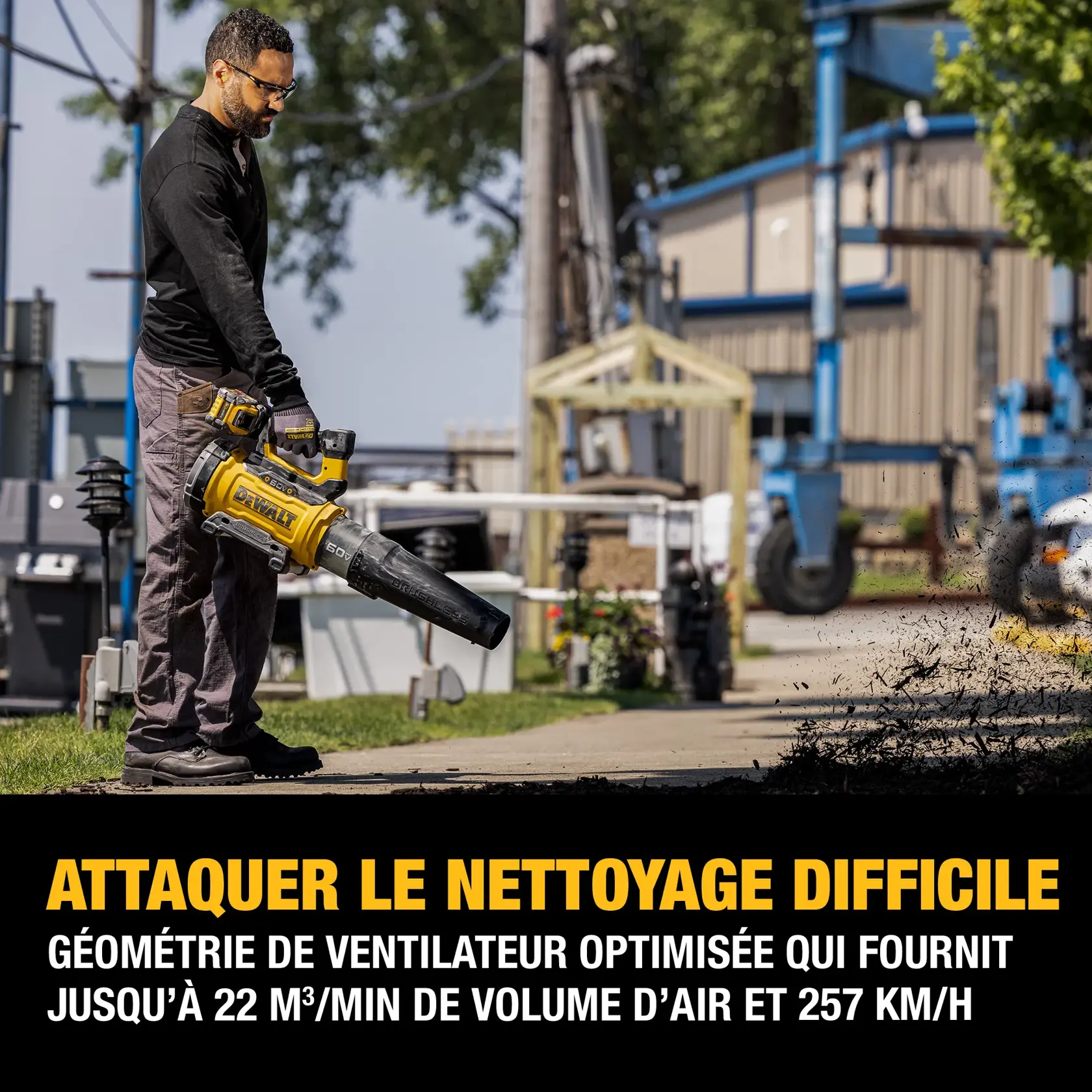 A person is using a DEWALT cordless leaf blower outdoors. The image includes a text overlay stating, 'Tackle Tough Clean-Up. Optimized fan geometry that provides up to 760 CFM of air volume and 160 MPH.' The person is blowing debris off a sidewalk, and there are industrial and outdoor elements in the background.