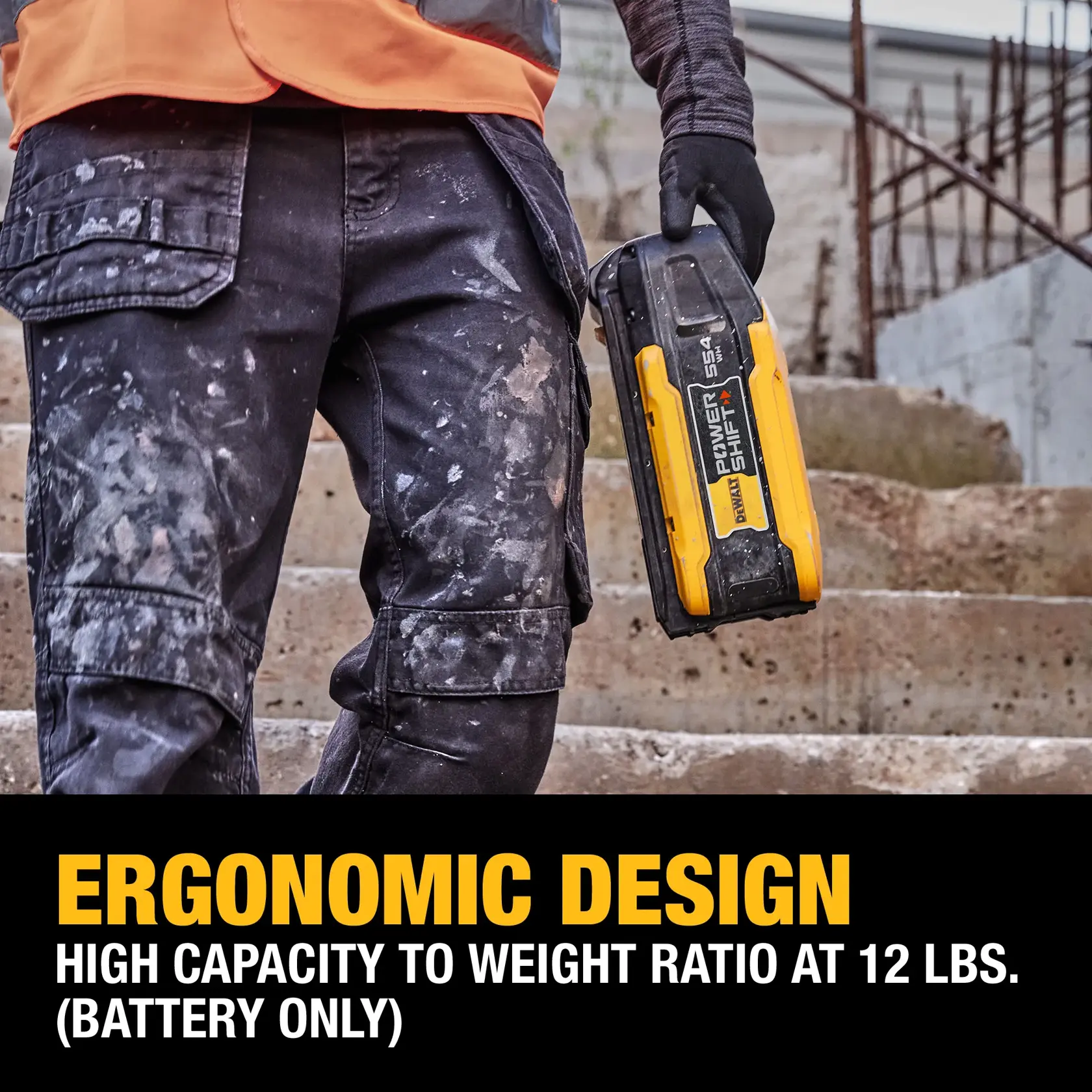A person wearing work gloves and paint-stained pants is holding a DEWALT PowerShift 554 battery. They are standing on concrete steps, and text below highlights the battery's ergonomic design and high capacity to weight ratio at 12 lbs (battery only).