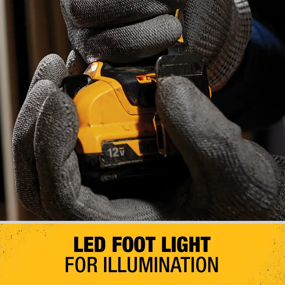 Close-up of gloved hands holding a DEWALT 12V power tool, highlighting the LED foot light feature for illumination. Text at the bottom reads: 'LED FOOT LIGHT FOR ILLUMINATION.'