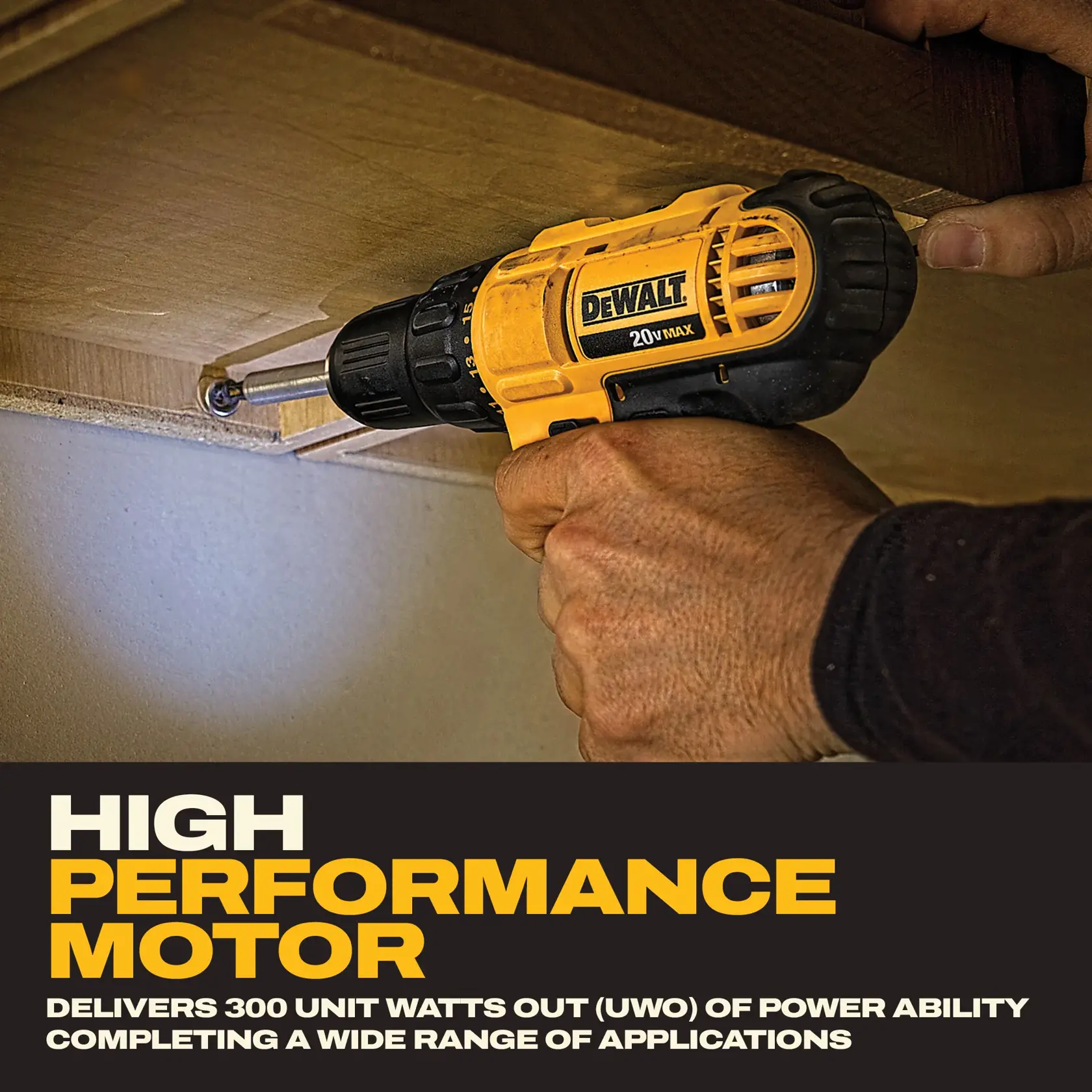 A DEWALT DCD771C2 cordless drill being used to screw into wood under a shelf. The drill is yellow and black and held by a person’s hand. Text at the bottom describes its high performance motor, delivering 300 unit watts out (UWO) for various applications.