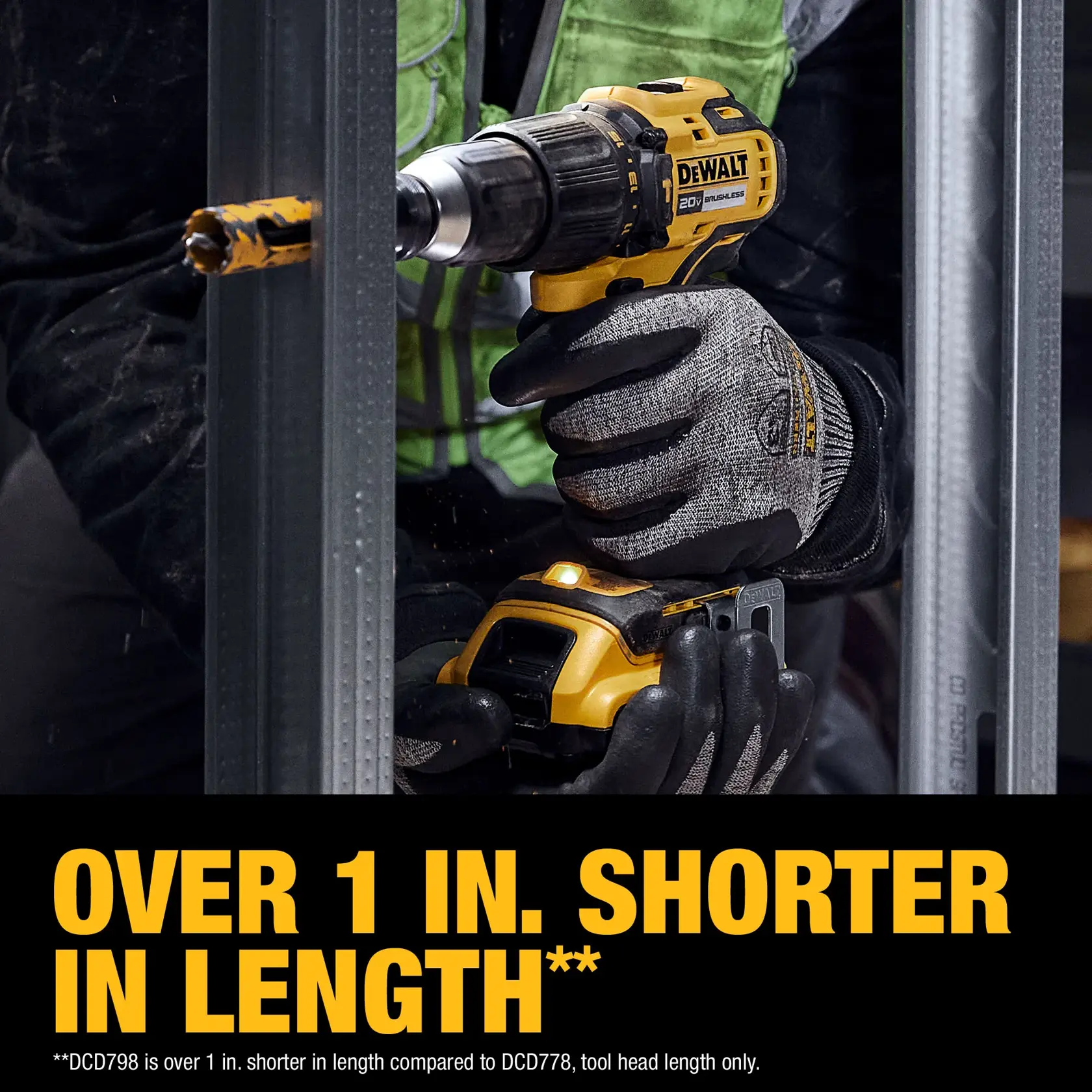 A person wearing work gloves uses a DEWALT 20V cordless drill, model DCD798D1, to drill into a metal frame. The image highlights that the tool is over 1 inch shorter in length compared to another model, with bold yellow text at the bottom.