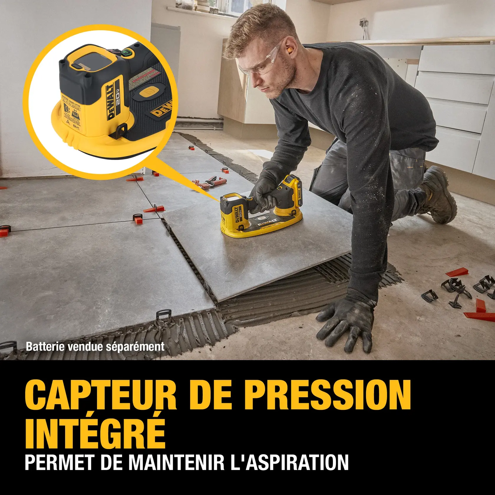 A person wearing gloves is installing large floor tiles in a kitchen using a DEWALT vacuum suction tool with a built-in pressure sensor. Various tile spacers and clips are scattered nearby. The text overlay highlights the tool’s built-in pressure sensor feature. The person's face is blurred. Battery is sold separately.
