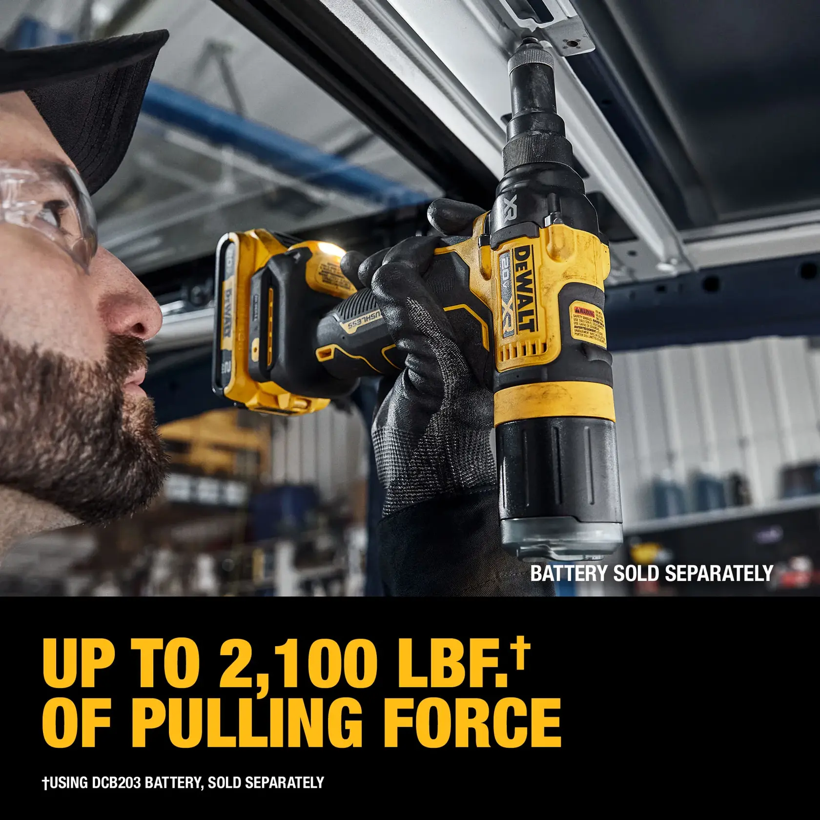 A person using a DEWALT cordless power tool, model DCF403B, to pull or install a fastener on a metal frame indoors. The tool is yellow and black, and the image highlights its pulling force of up to 2,100 lbf. Text notes that the battery is sold separately.