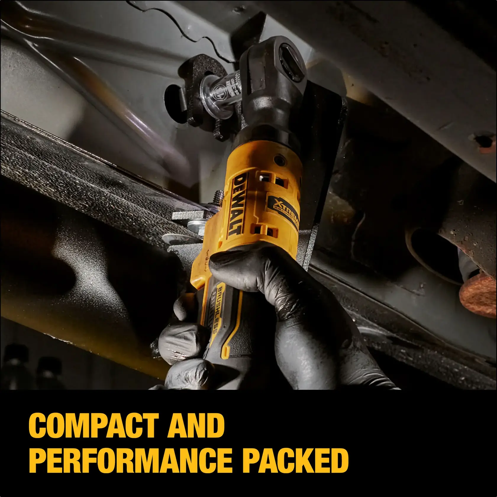 A close-up of a person using a DEWALT cordless ratchet tool to tighten a bolt in a tight space under a vehicle. The tool is yellow and black, and the person is wearing black gloves. The image features the text 'COMPACT AND PERFORMANCE PACKED' at the bottom.