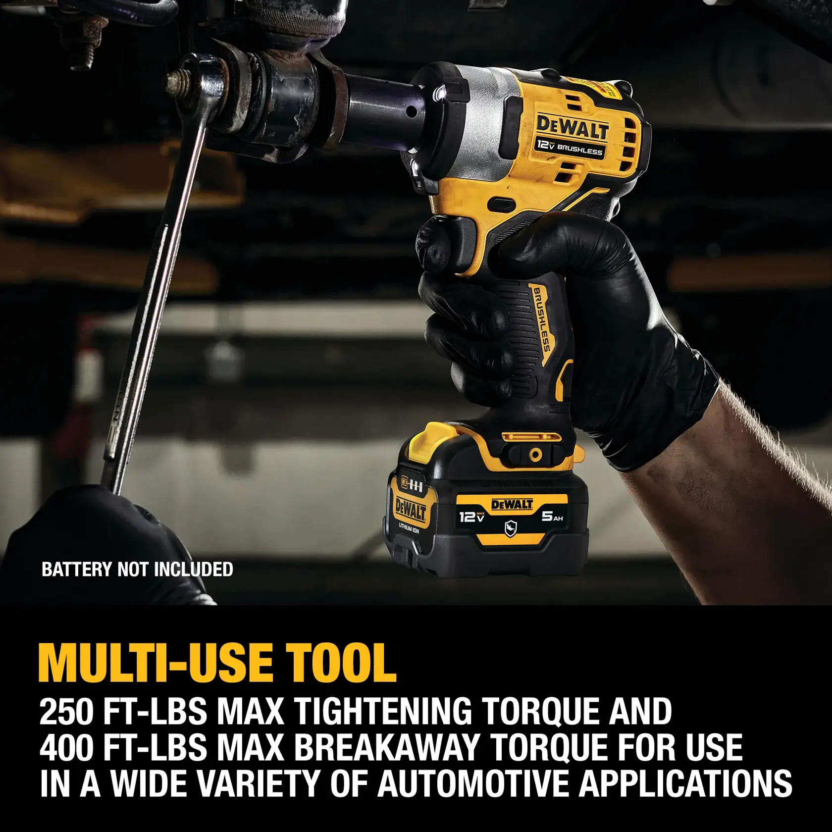 A person wearing black gloves uses a DEWALT 12V brushless cordless impact wrench (model DCF901B) to work on an automotive part underneath a vehicle. The tool is shown in action tightening a bolt. Text mentions: 'Multi-use tool. 250 ft-lbs max tightening torque and 400 ft-lbs max breakaway torque for use in a wide variety of automotive applications.' Note: battery not included.
