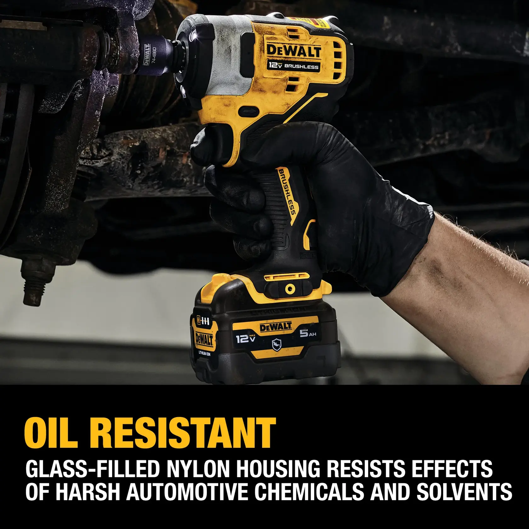 A person wearing a black glove is using a DEWALT 12V brushless impact wrench to work on automotive parts. The tool features oil resistance and a glass-filled nylon housing that resists harsh automotive chemicals and solvents, as highlighted by the text in the image.
