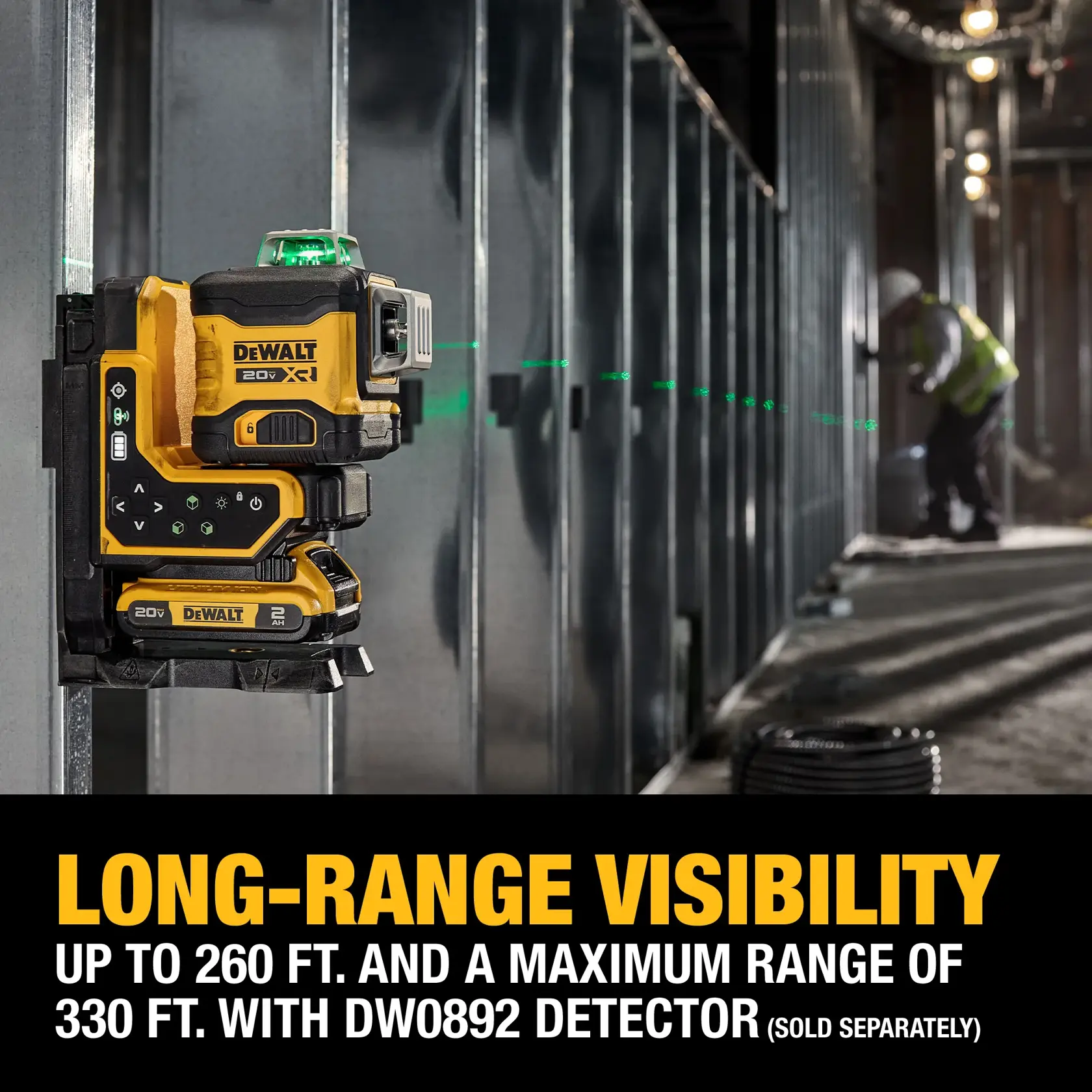 A DEWALT 20V XR green laser level is mounted on a metal frame inside a construction site. The device projects a long, visible green laser line across the room. Text on the image highlights long-range visibility, reaching up to 260 feet and a maximum of 330 feet with the DW0892 detector, which is sold separately.