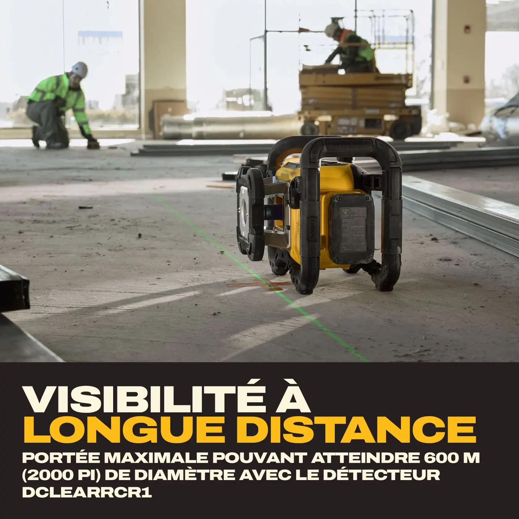 Un outil laser DEWALT est posé sur le sol d’un chantier, projetant une ligne verte visible à travers la pièce. Deux travailleurs de la construction sont visibles à l’arrière-plan, l’un agenouillé et l’autre sur un équipement en hauteur. Le texte indique « VISIBILITÉ À LONGUE PORTÉE » et précise une portée maximale jusqu’à 2 000 pieds (600 mètres) de diamètre avec le détecteur DCLEARCR1.