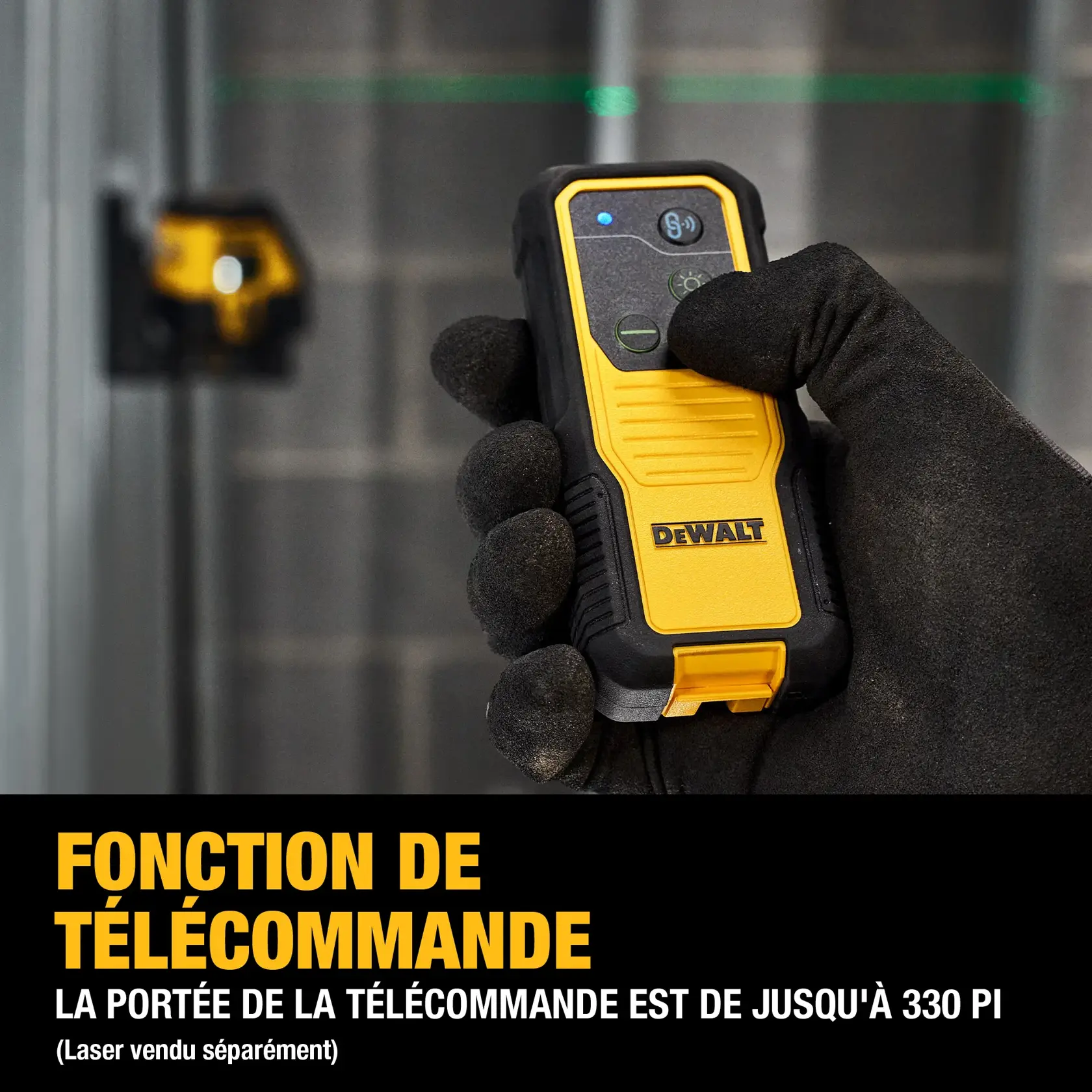 A gloved hand holding a DEWALT remote control device, with a yellow and black design. The background shows a DEWALT laser level tool mounted on a wall. Text at the bottom highlights long-range functionality of up to 330 feet for remote control range, and notes that the laser is sold separately.