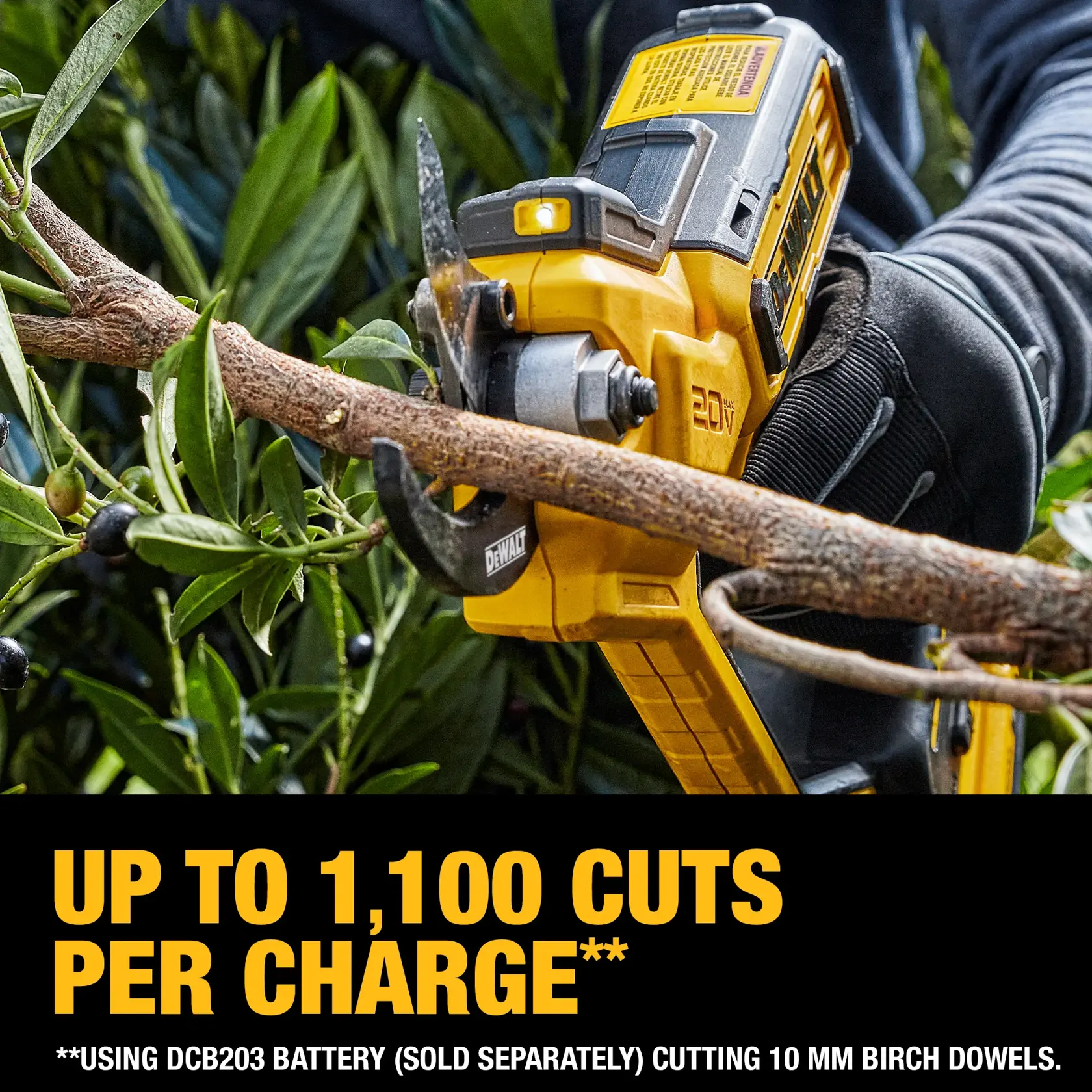 A person wearing gloves using a yellow DEWALT 20V cordless pruning shear to cut a tree branch. The text below highlights that the tool can make up to 1,100 cuts per charge when using a DCB203 battery, which is sold separately, on 10 mm birch dowels.