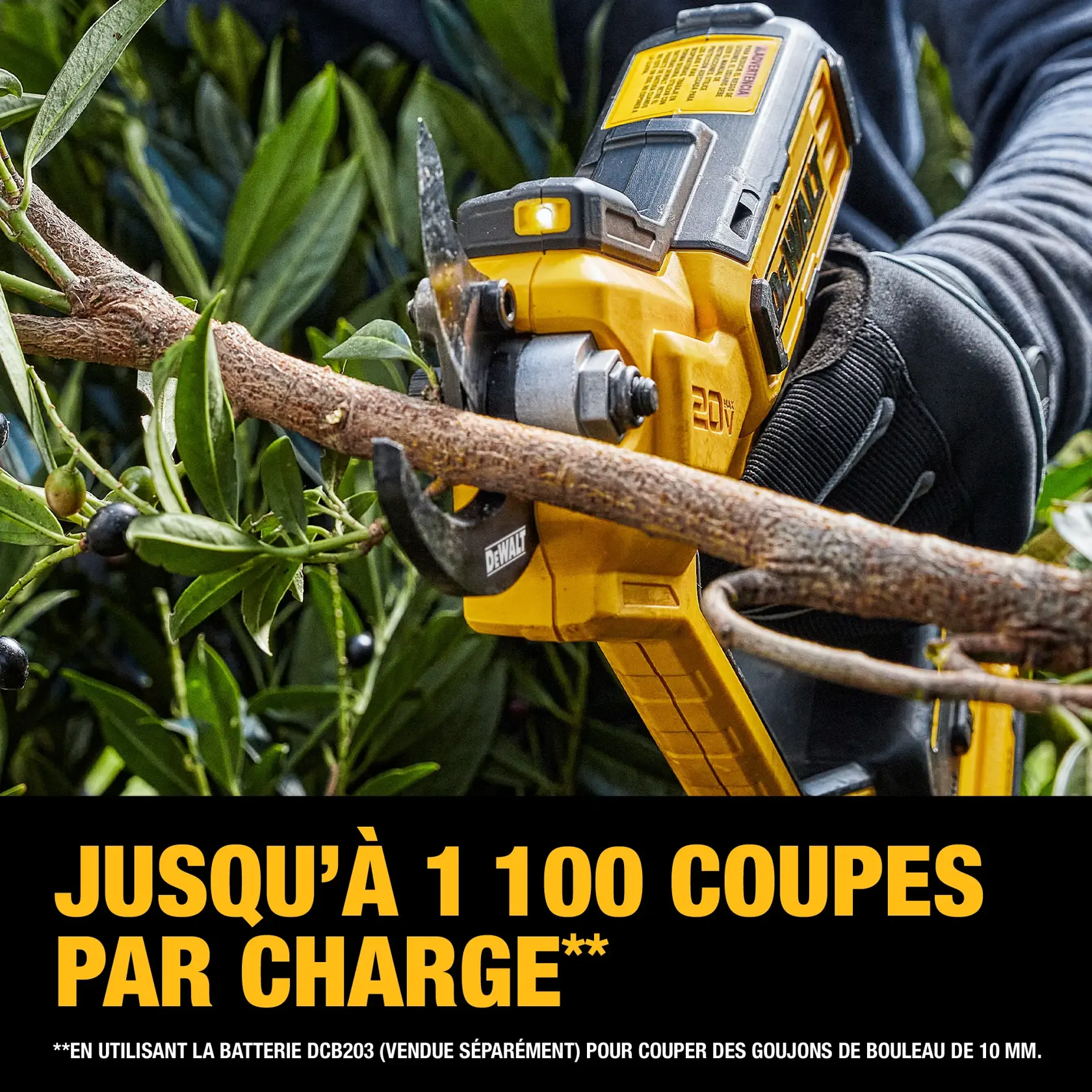 A person wearing gloves using a yellow DEWALT 20V cordless pruning shear to cut a tree branch. The text below highlights that the tool can make up to 1,100 cuts per charge when using a DCB203 battery, which is sold separately, on 10 mm birch dowels.