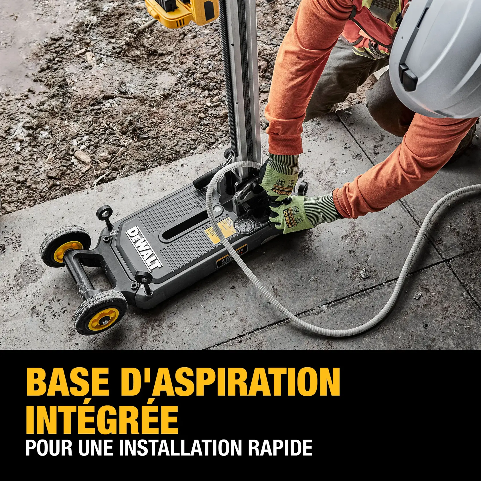 A DEWALT power tool with an integrated vacuum base is being set up by a worker wearing gloves and a safety helmet on a concrete surface. The tool features yellow wheels and is connected to a hose. Text on the image reads 'Integrated vacuum base for a quick secure set-up.'