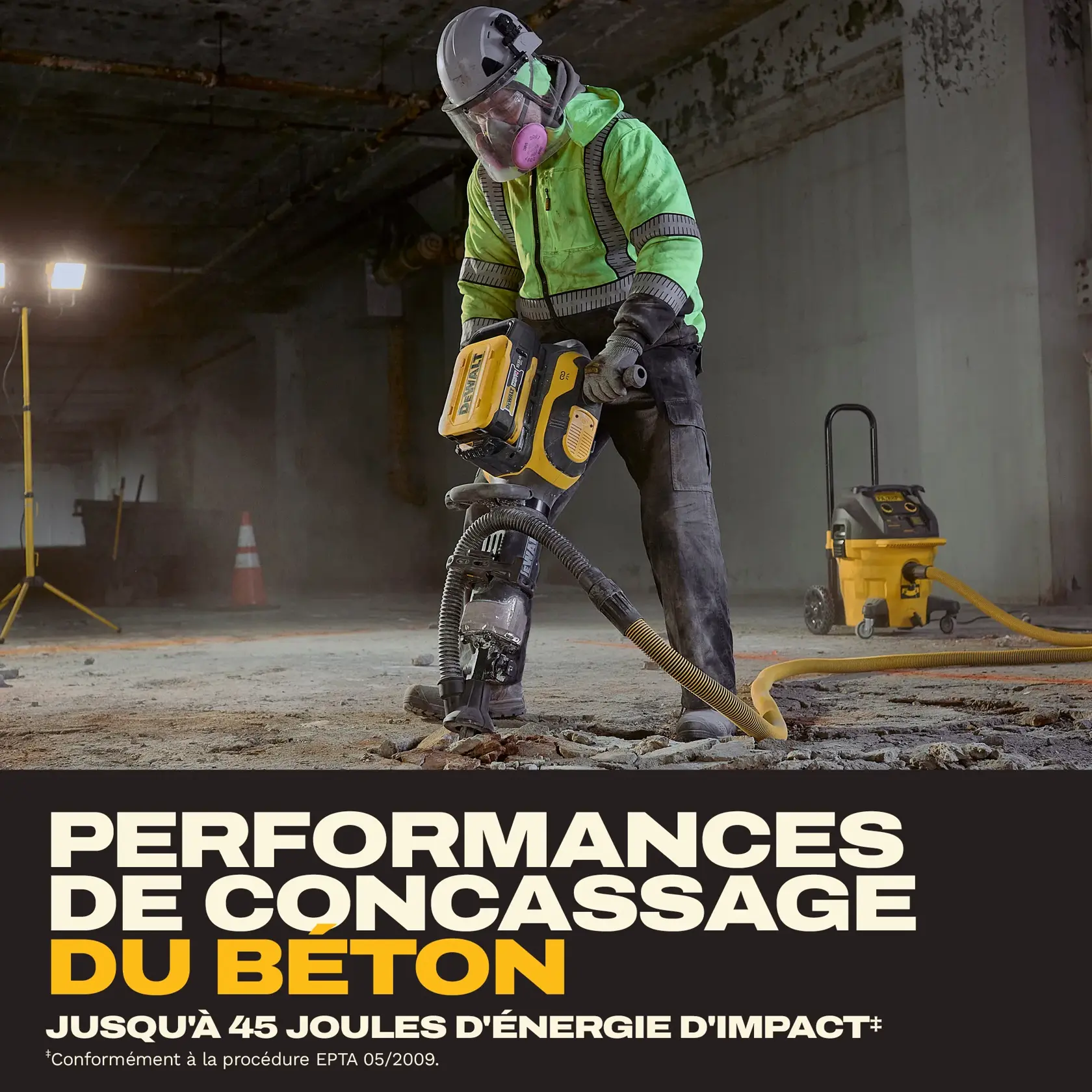 Worker in safety gear uses a DEWALT jackhammer to break concrete in an industrial setting.