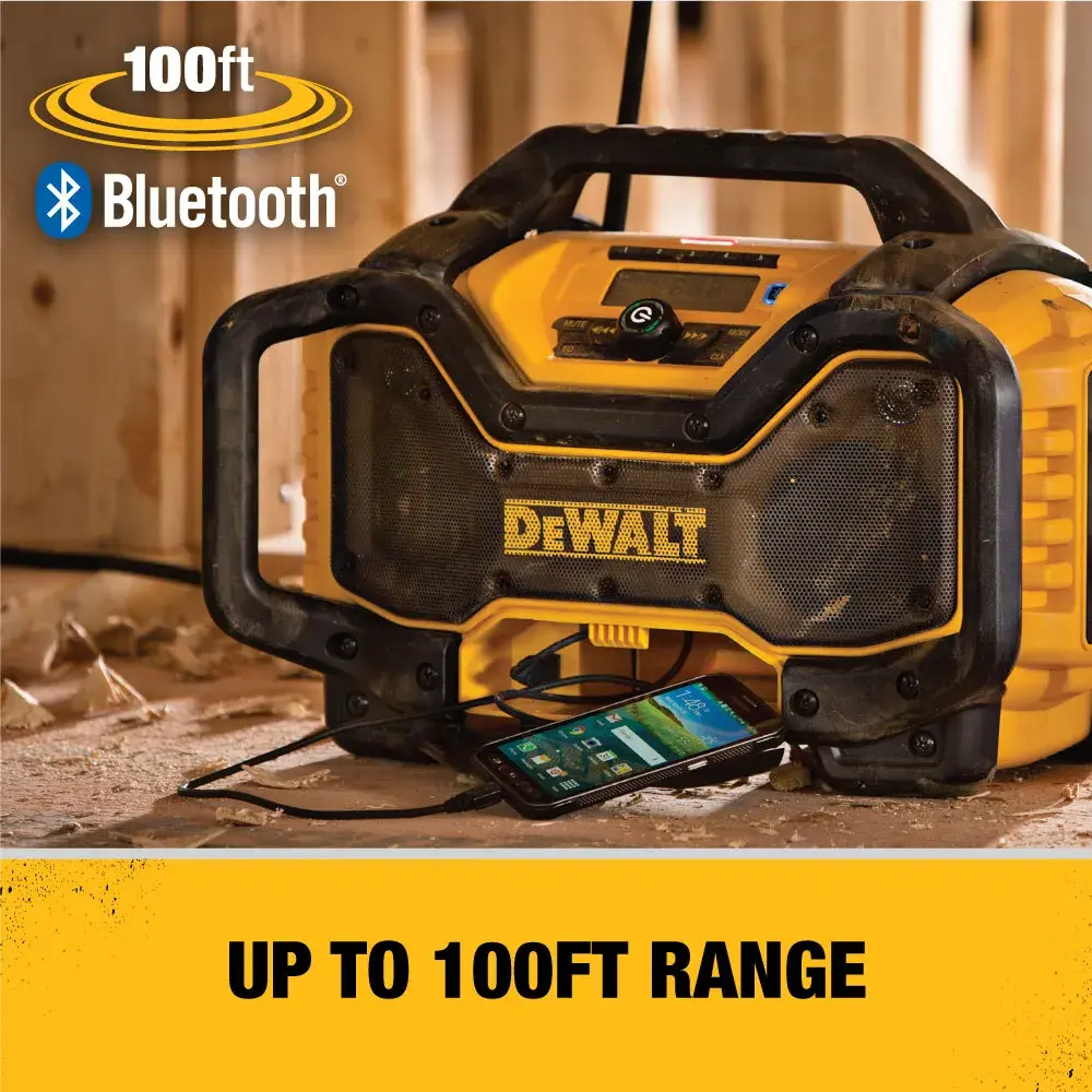 A DEWALT portable Bluetooth radio is shown inside a workshop. The radio is yellow and black with rugged protective bumpers, and a smartphone is connected to it. Text on the image indicates Bluetooth capability with up to 100-foot range.