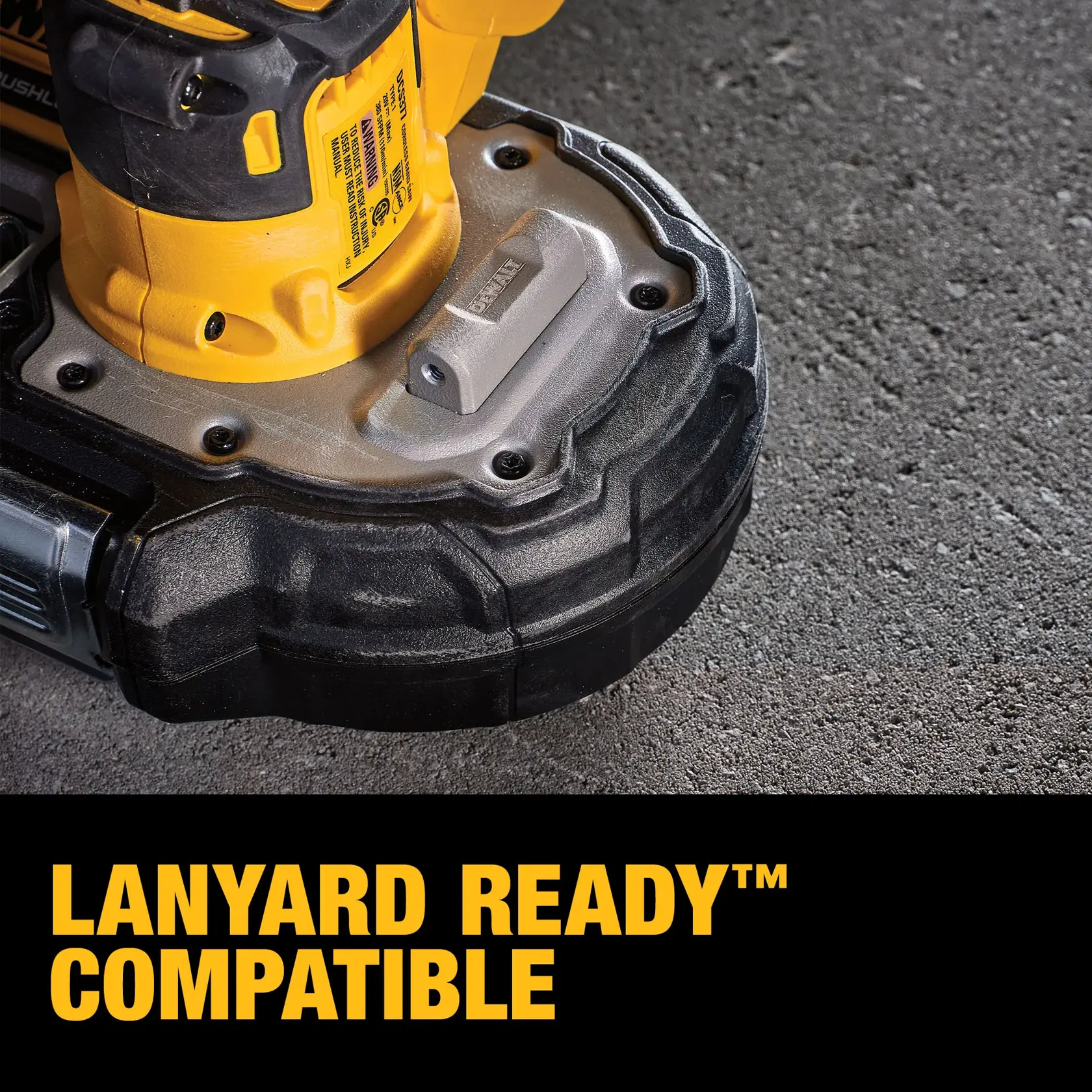 Close-up of a DEWALT power tool base sitting on a concrete surface, showing a lanyard attachment point. The bottom text reads 'LANYARD READY™ COMPATIBLE' in bold yellow letters.