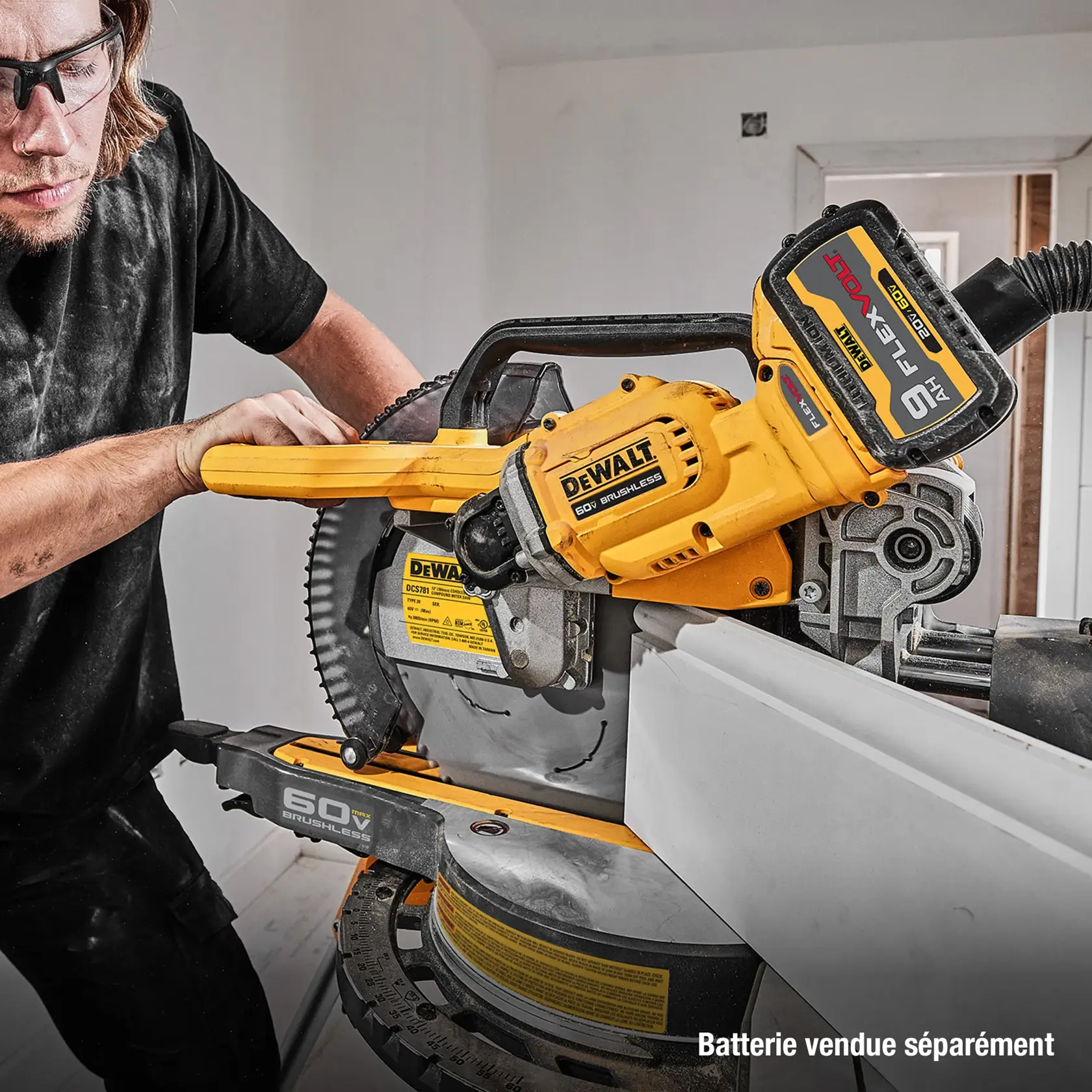 A person using a DEWALT 60V brushless miter saw to cut a piece of white trim, with a large FlexVolt battery attached. The text on the image reads, 'Battery sold separately.'