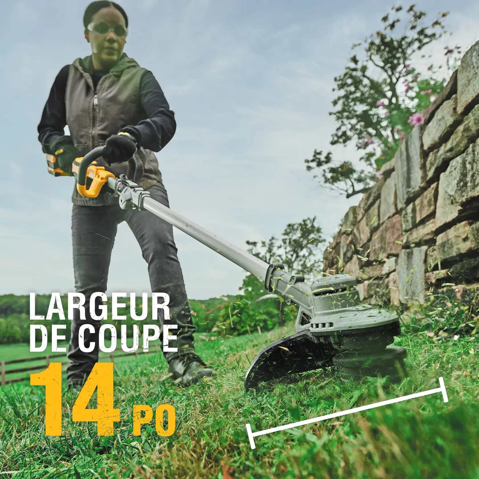 Person using a DEWALT string trimmer outdoors, showing 14 inch cutting swath near a stone wall.