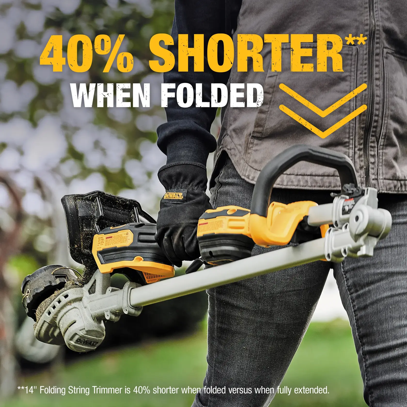 A person using a DEWALT cordless string trimmer to cut grass along a stone wall outdoors, with a green landscape and blue sky in the background. The person's face is blurred.