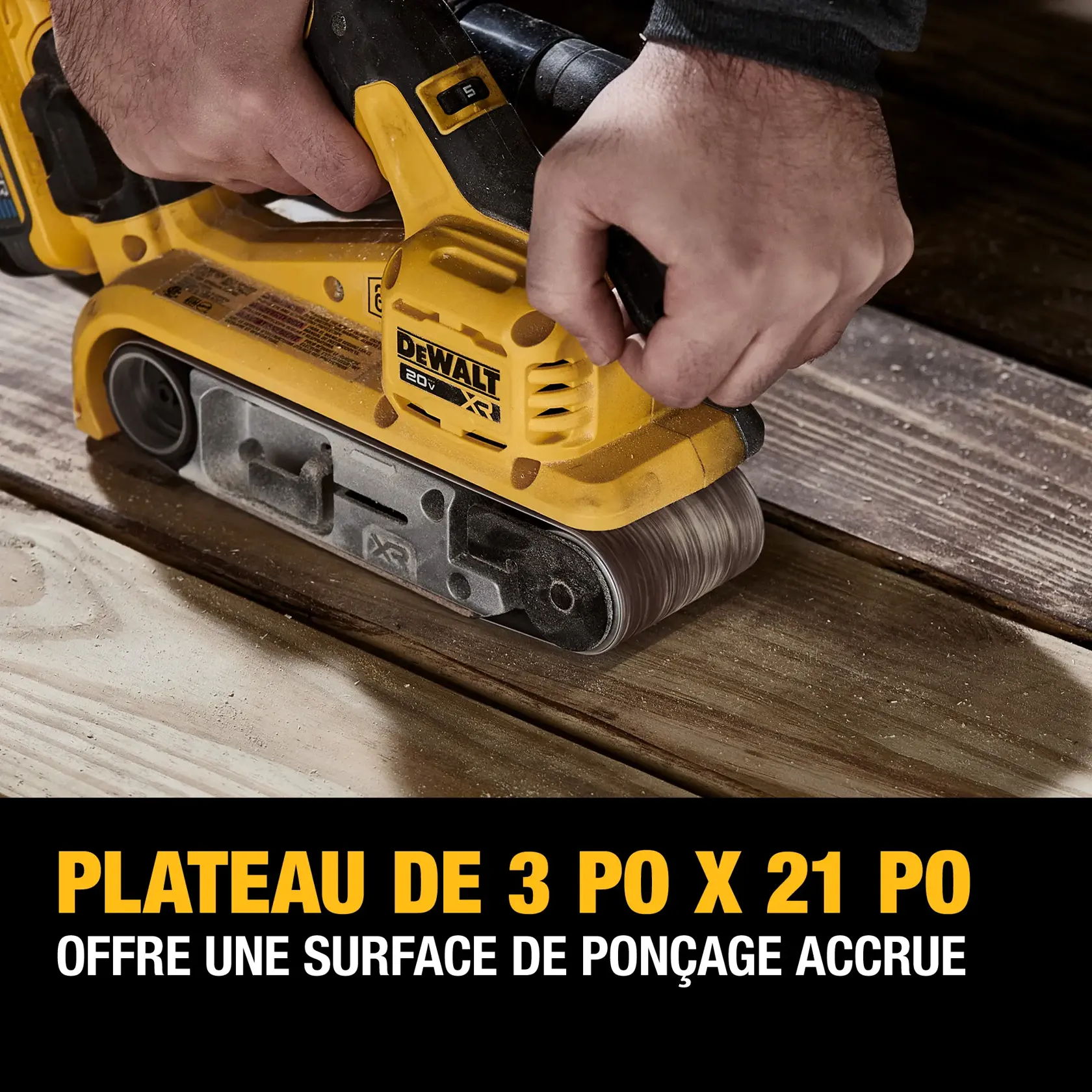 A person using a yellow DEWALT 20V XR belt sander to sand wooden planks. The bottom text in French states: '3-inch x 21-inch plate offers an increased sanding surface.'