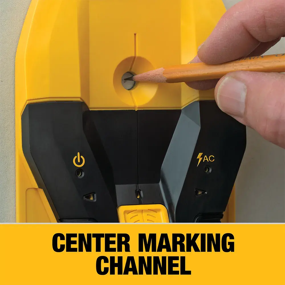 A close-up of a DEWALT device being used, showing a hand holding a pencil to mark through the center marking channel on the tool. The device has power and AC symbols, and text below reads 'CENTER MARKING CHANNEL.'