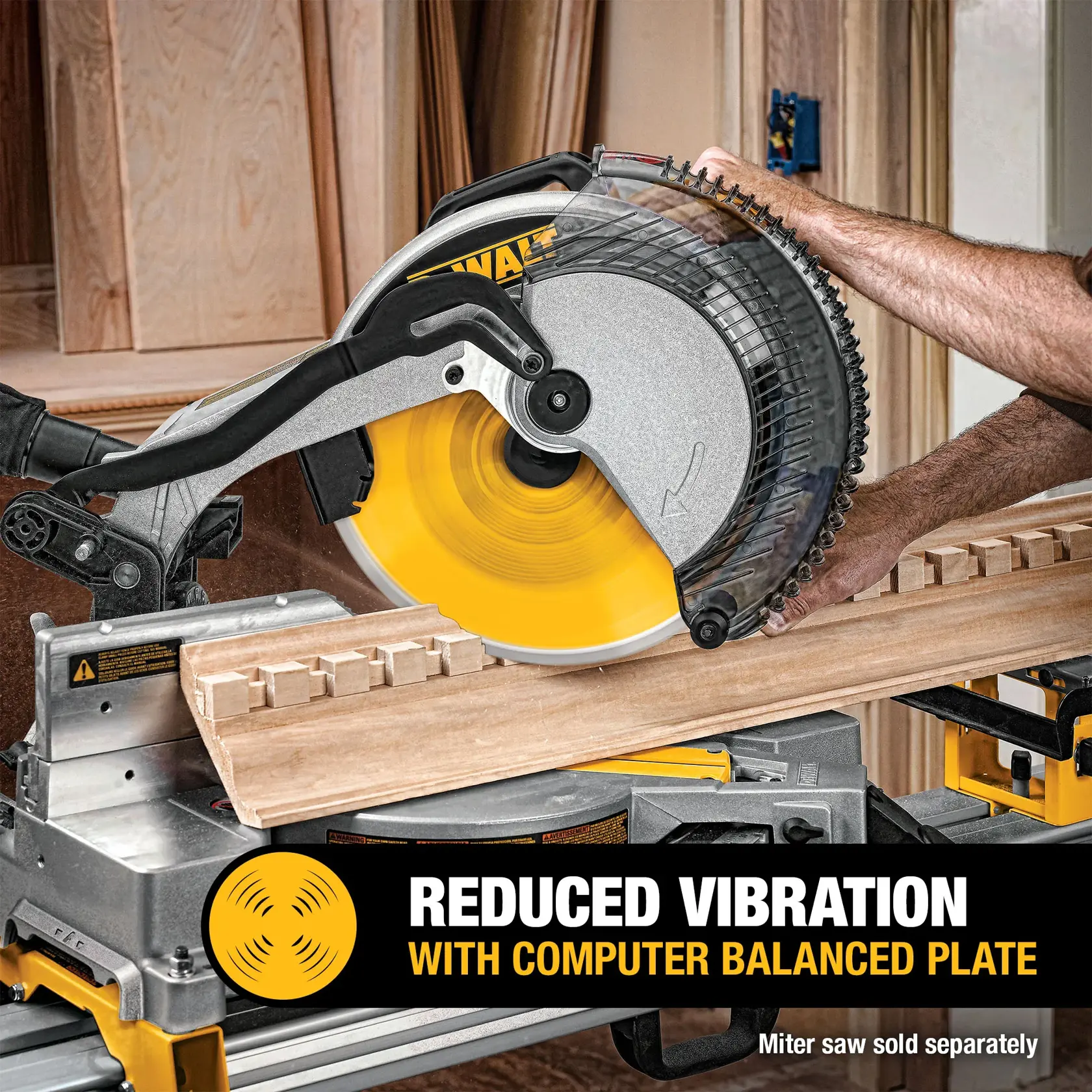 A DEWALT miter saw blade in use, cutting wood. The image highlights the feature of reduced vibration with a computer balanced plate. A person's hand is holding the wood, and the miter saw is seen in a workshop setting. Text at the bottom reads: 'Reduced vibration with computer balanced plate. Miter saw sold separately.'