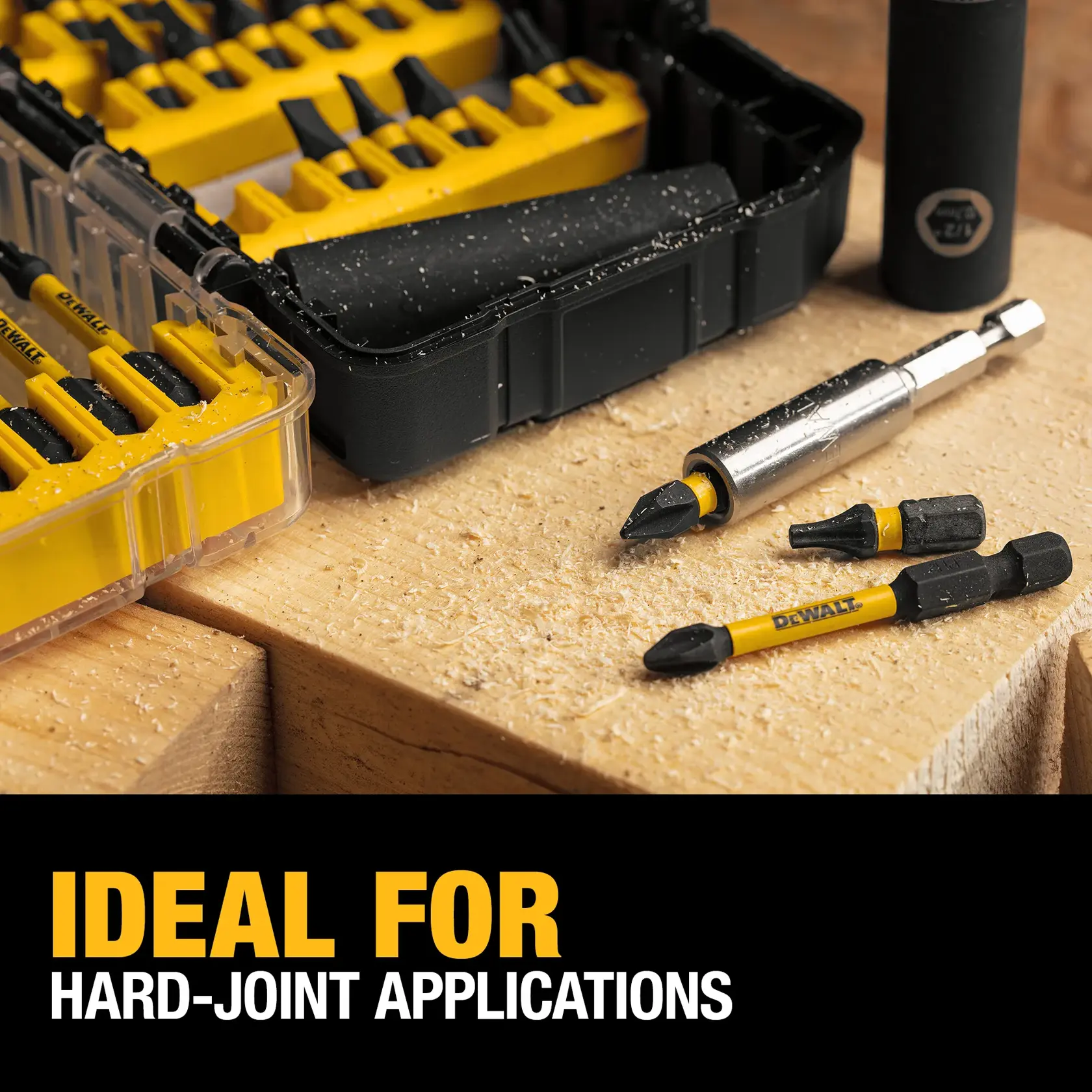 Close-up of a DEWALT drill bit set with yellow and black bits in plastic cases, placed on a wooden surface with sawdust. Text reads: 'IDEAL FOR HARD-JOINT APPLICATIONS'.