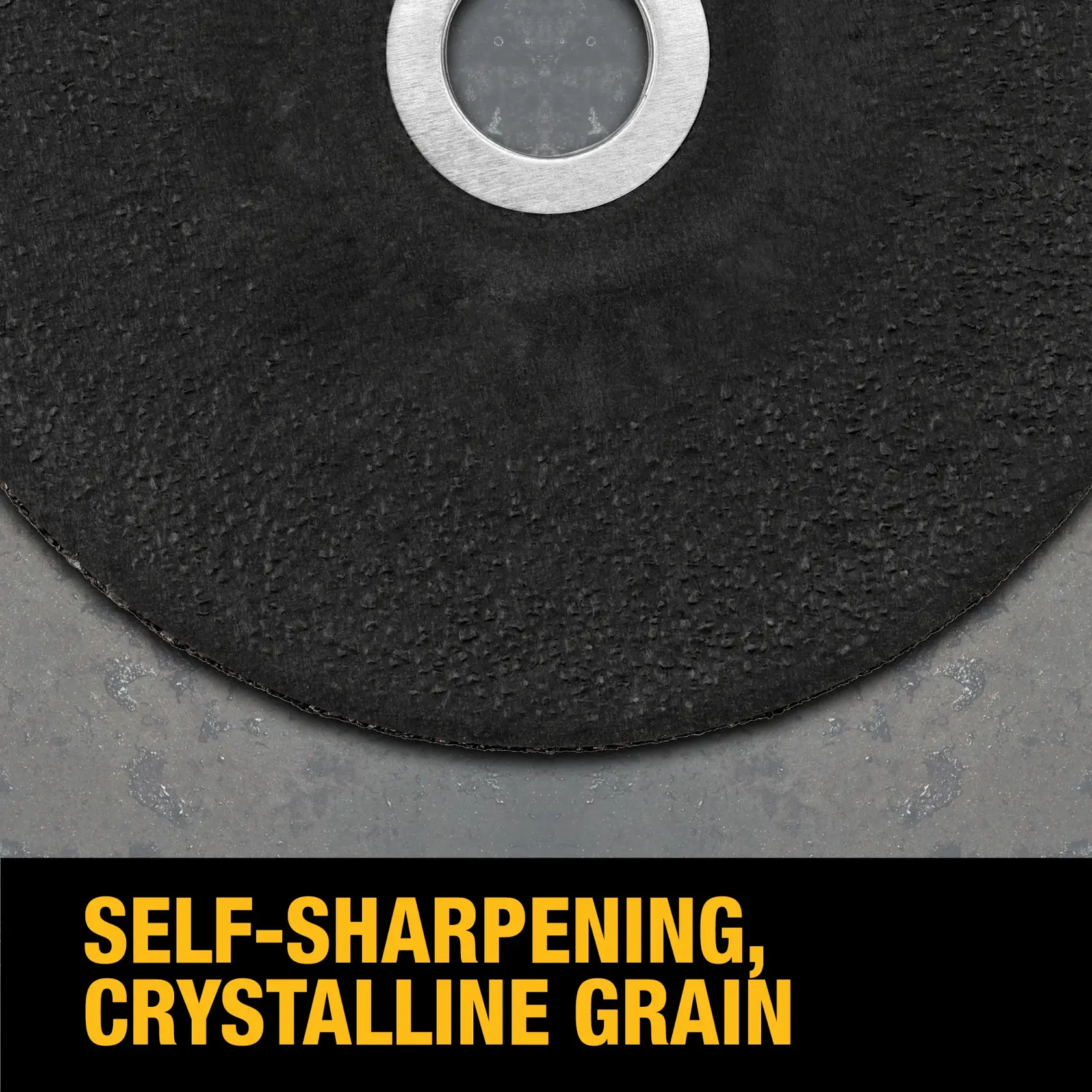 Close-up of a DEWALT grinding wheel with a textured black surface and metal center, placed on a gray stone background. Text at the bottom reads 'Self-sharpening, crystalline grain' in yellow letters.