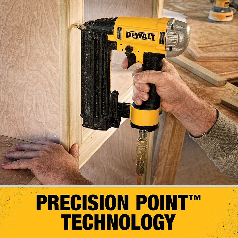 A person using a DEWALT pneumatic nail gun to attach wood trim, with the text 'PRECISION POINT™ TECHNOLOGY' displayed below the image.