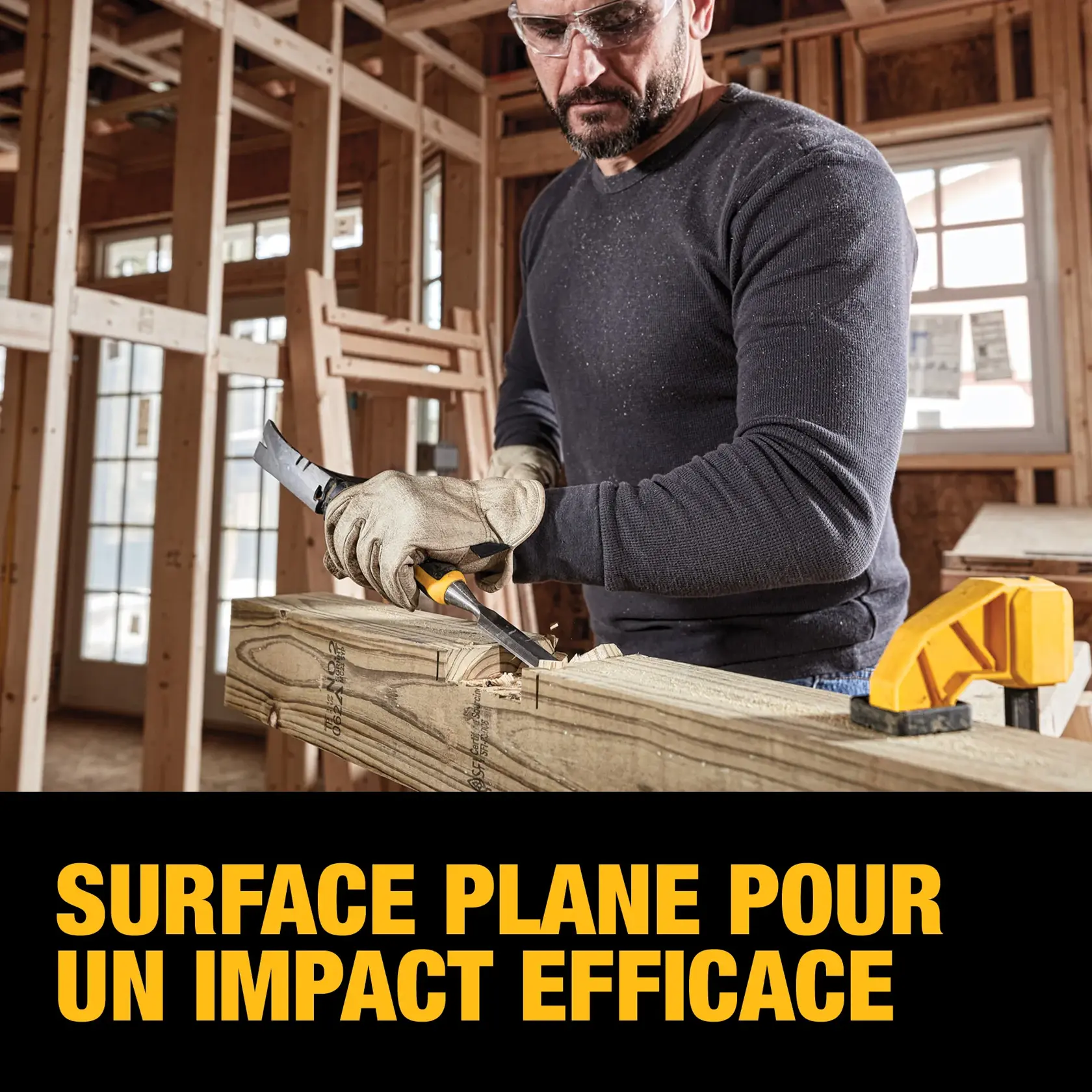 A person wearing gloves uses a DEWALT hand tool to work on a piece of wood in a construction setting. The image highlights the tool's flat striking surface. The text reads: 'FLAT SURFACE FOR STRIKING.'