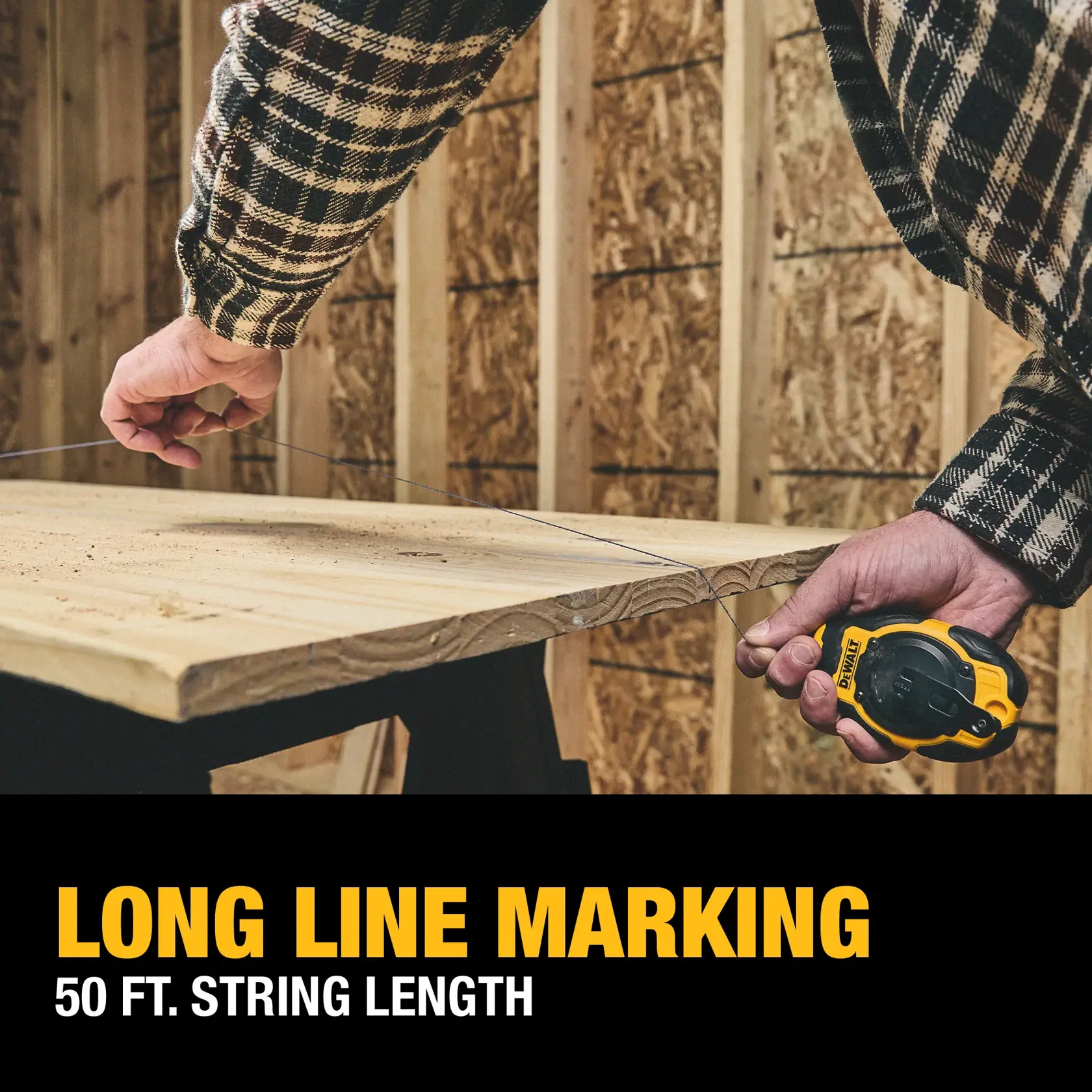 A person uses a DEWALT chalk line tool to mark a long straight line across a wooden board. The tool features a 50-foot string length and is being used in a construction setting.