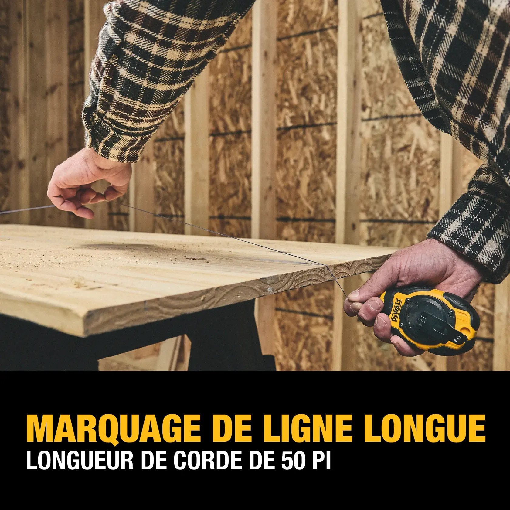 A person uses a DEWALT chalk line tool to mark a long straight line across a wooden board. The tool features a 50-foot string length and is being used in a construction setting.