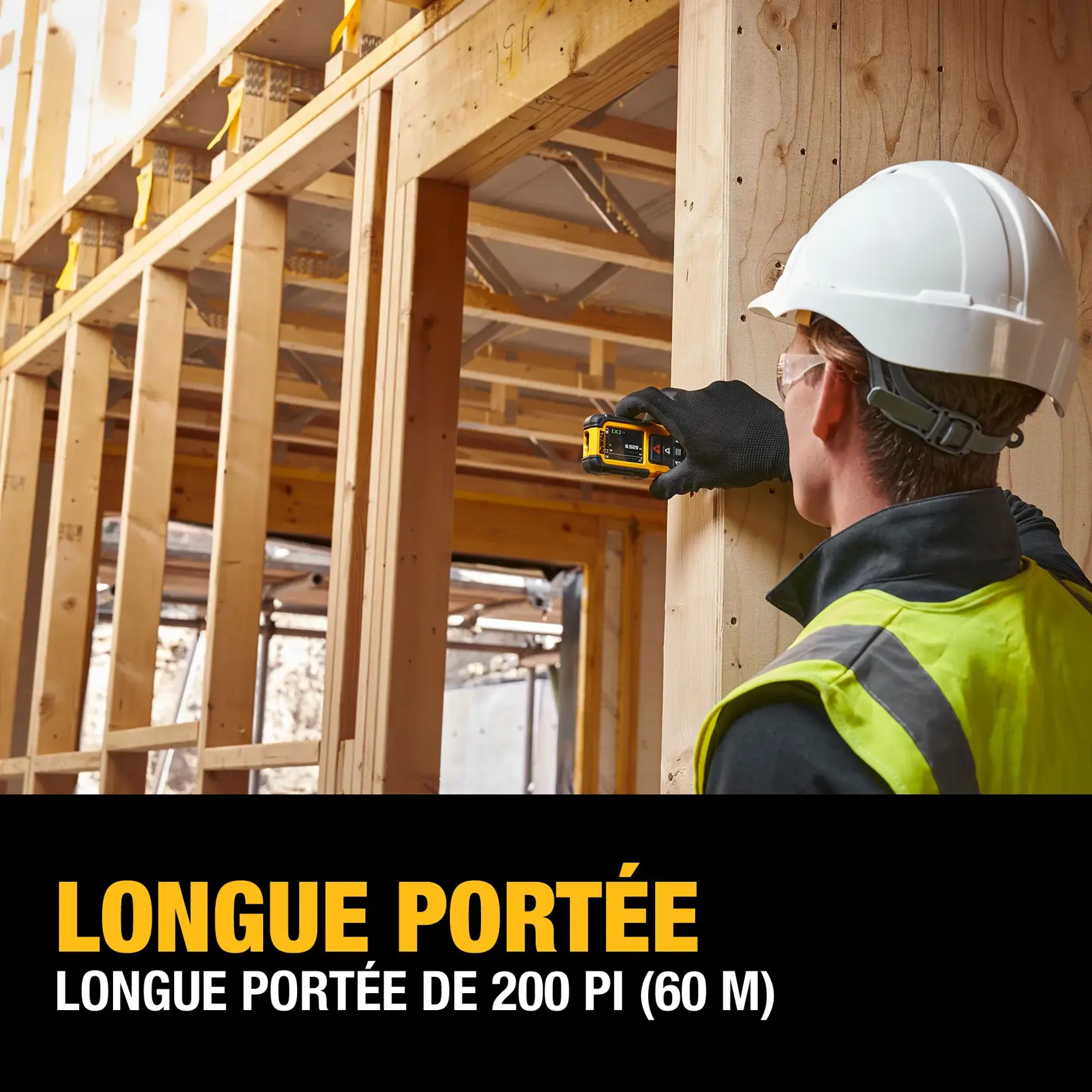 A person wearing a hard hat, safety vest, and gloves is using a DEWALT laser distance measurer on a wooden construction site. Text on the image reads: 'LONG RANGE. LARGE 200 FT. (60M) RANGE.'