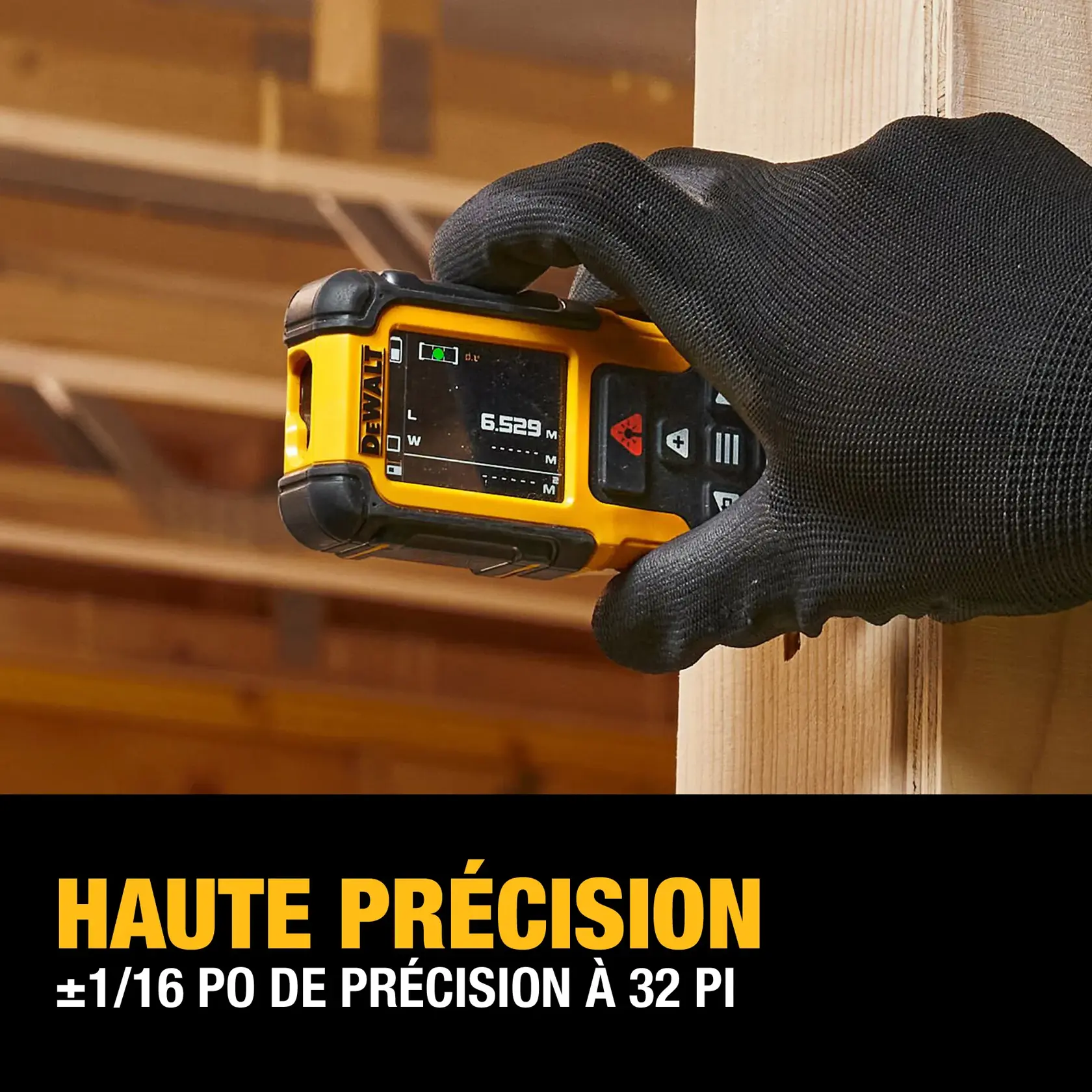 A gloved hand holds a DEWALT laser distance measurer against a wooden beam inside a construction site. The device screen displays a measurement. Text below reads 'HIGH ACCURACY ±1/16 IN. ACCURACY AT 32 FT.'