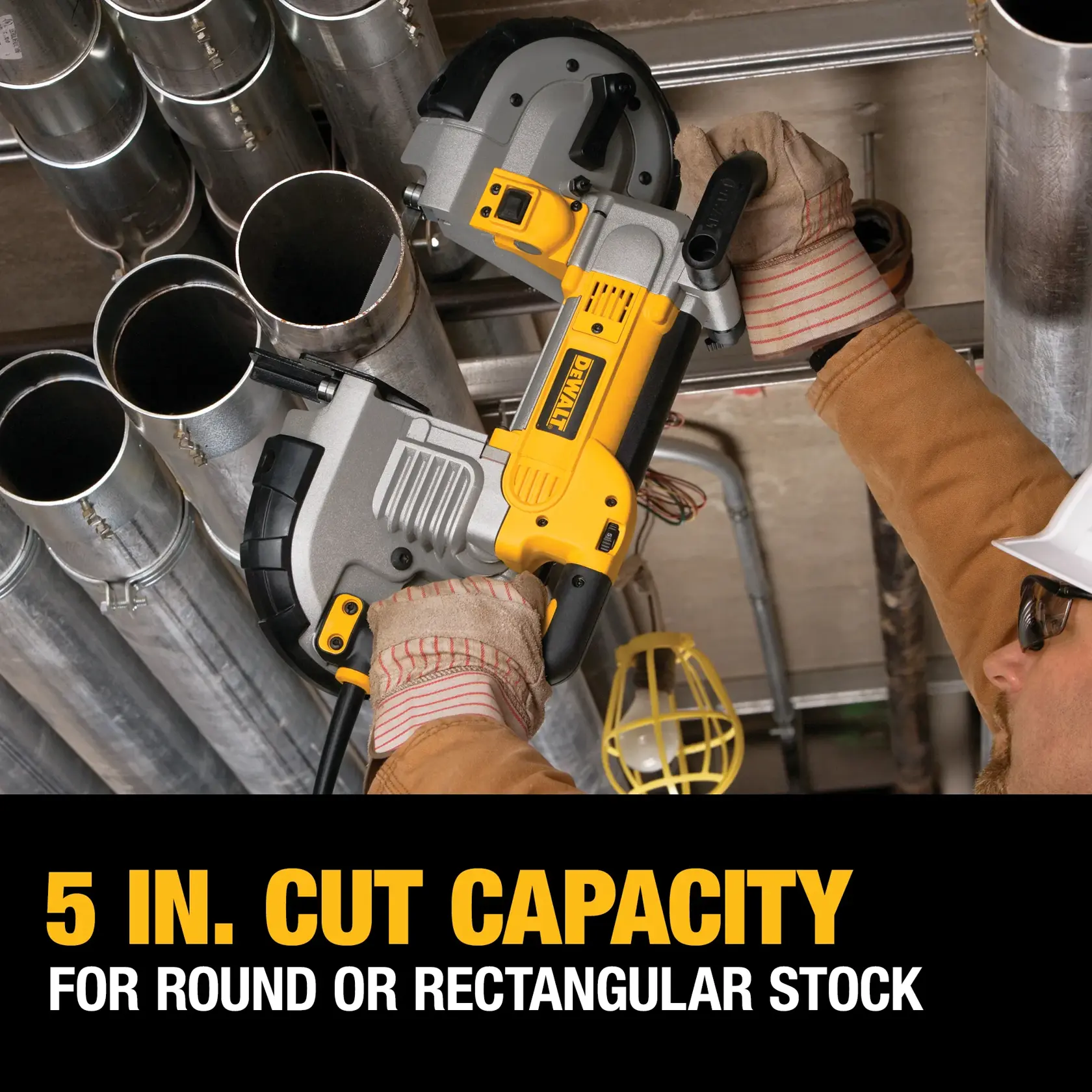 A worker wearing gloves and a helmet uses a DEWALT portable band saw to cut a metal pipe among several pipes. The saw is shown in use, highlighting its 5-inch cut capacity for round or rectangular stock, as indicated by the text at the bottom of the image.
