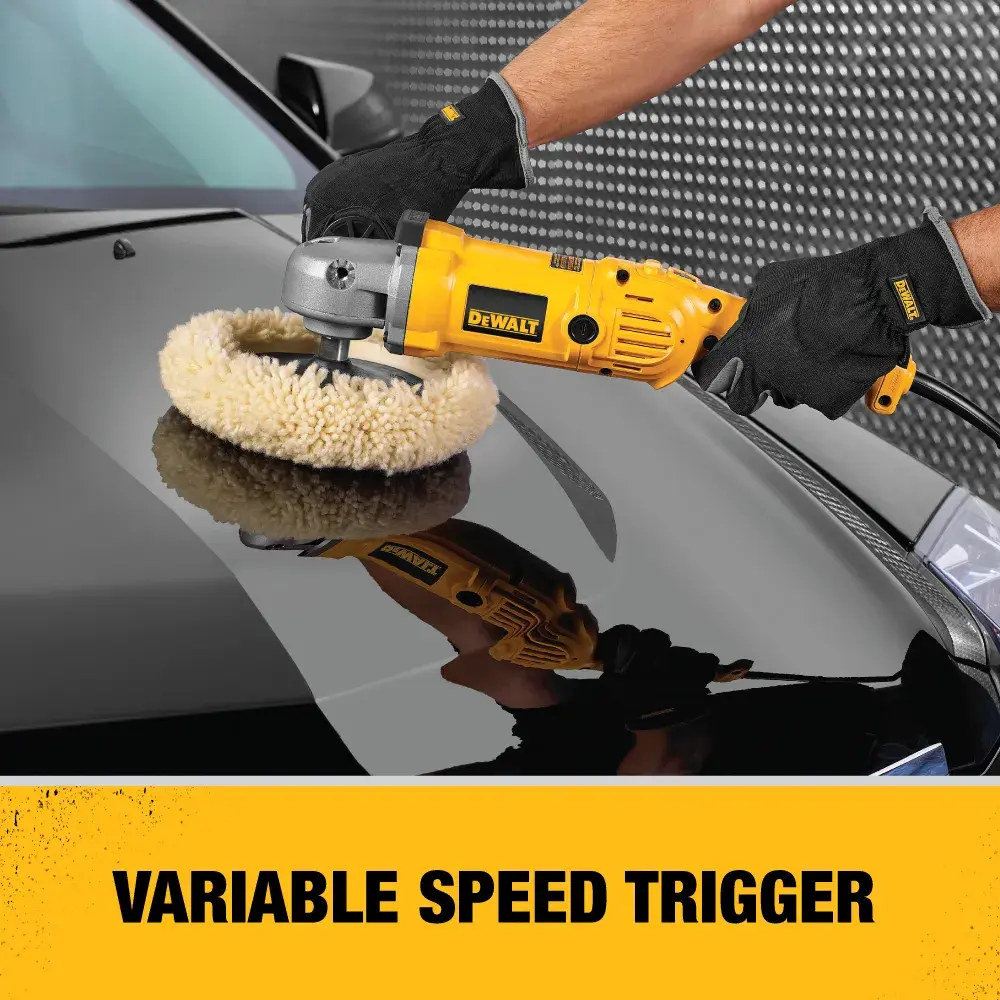 A person wearing black gloves is using a yellow DEWALT variable speed polisher on the hood of a black car.