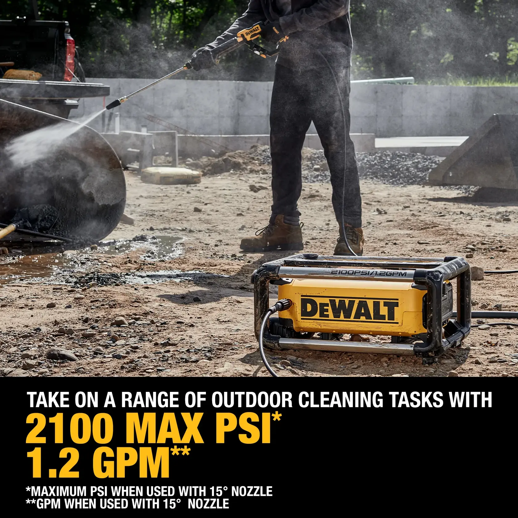 A DEWALT pressure washer is being used outdoors at a construction site. The device is spraying water to clean a metal surface. The text highlights its features: 2100 max PSI and 1.2 GPM when used with a 15° nozzle.
