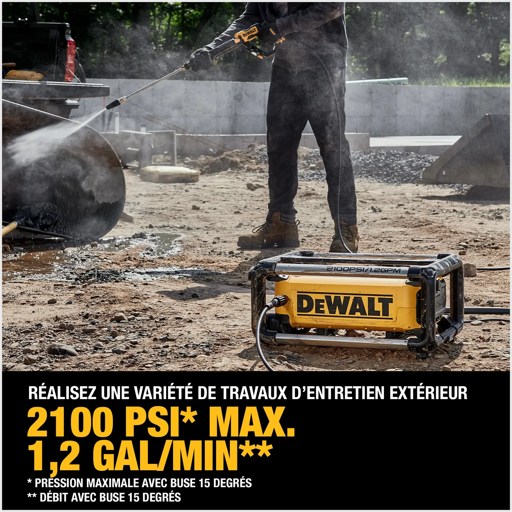 A DEWALT pressure washer is being used outdoors at a construction site. The device is spraying water to clean a metal surface. The text highlights its features: 2100 max PSI and 1.2 GPM when used with a 15° nozzle.
