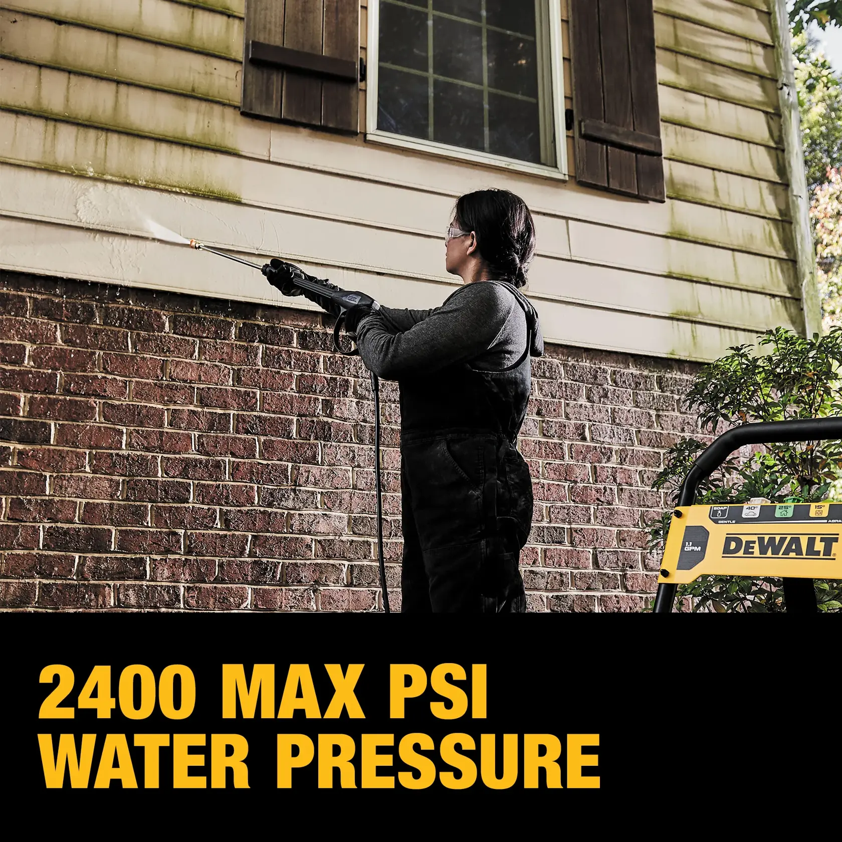 A person is using a DEWALT pressure washer to clean the exterior siding of a house, showing the removal of grime with high water pressure. Text on the image states '2400 MAX PSI WATER PRESSURE.'