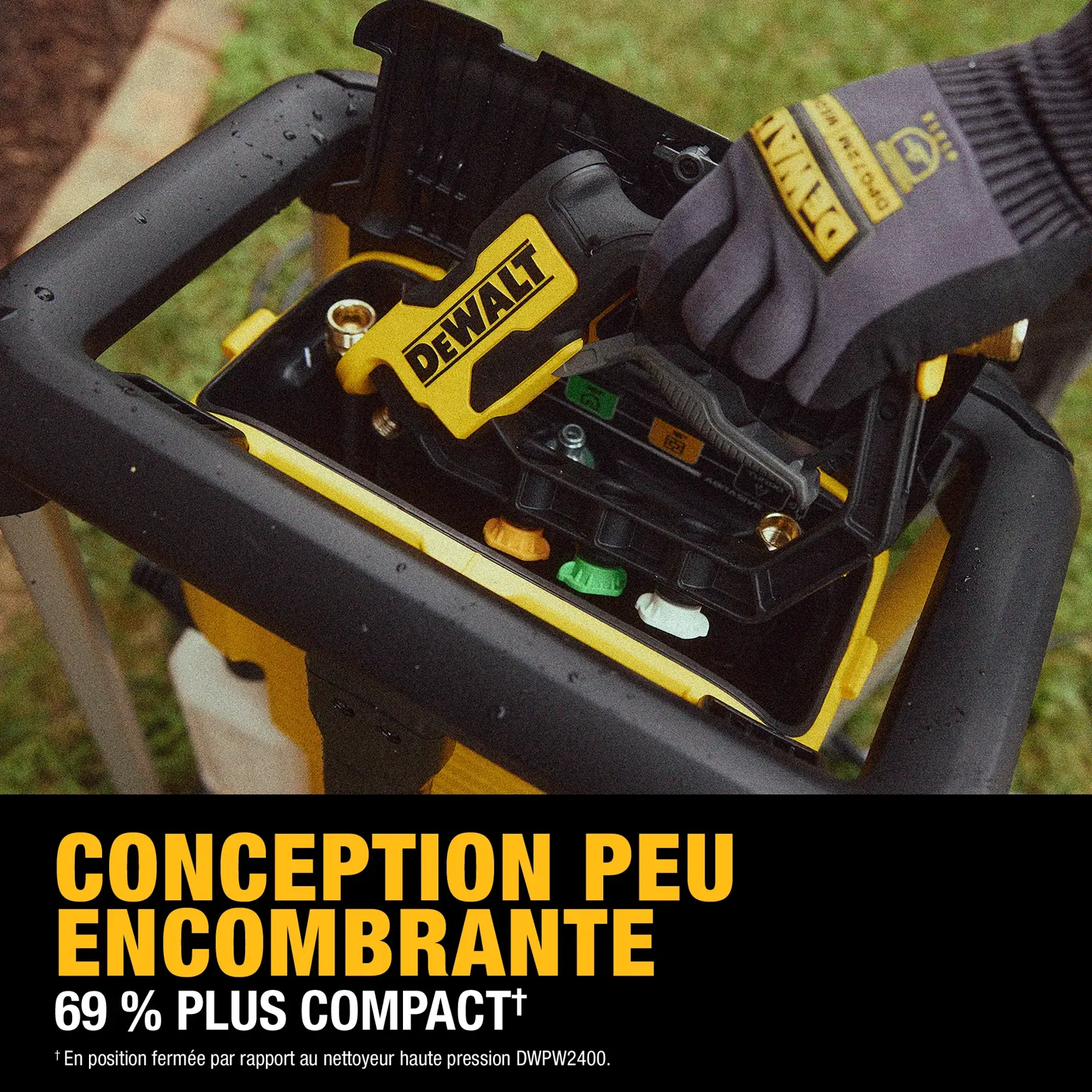 A close-up of a DEWALT pressure washer being stored compactly with a gloved hand placing the spray gun inside the unit. Text on the image highlights the space-saving design, stating it is 69% more compact compared to the DWPW2400 model.