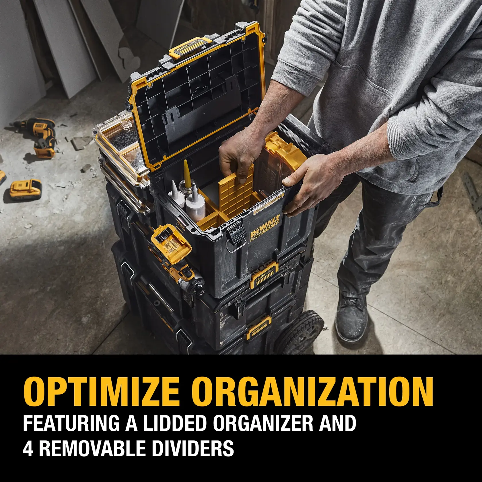 A person organizing tools in a DEWALT stackable tool storage box with a lidded organizer and 4 removable dividers. The box is black with yellow accents and is part of a modular storage system on wheels.