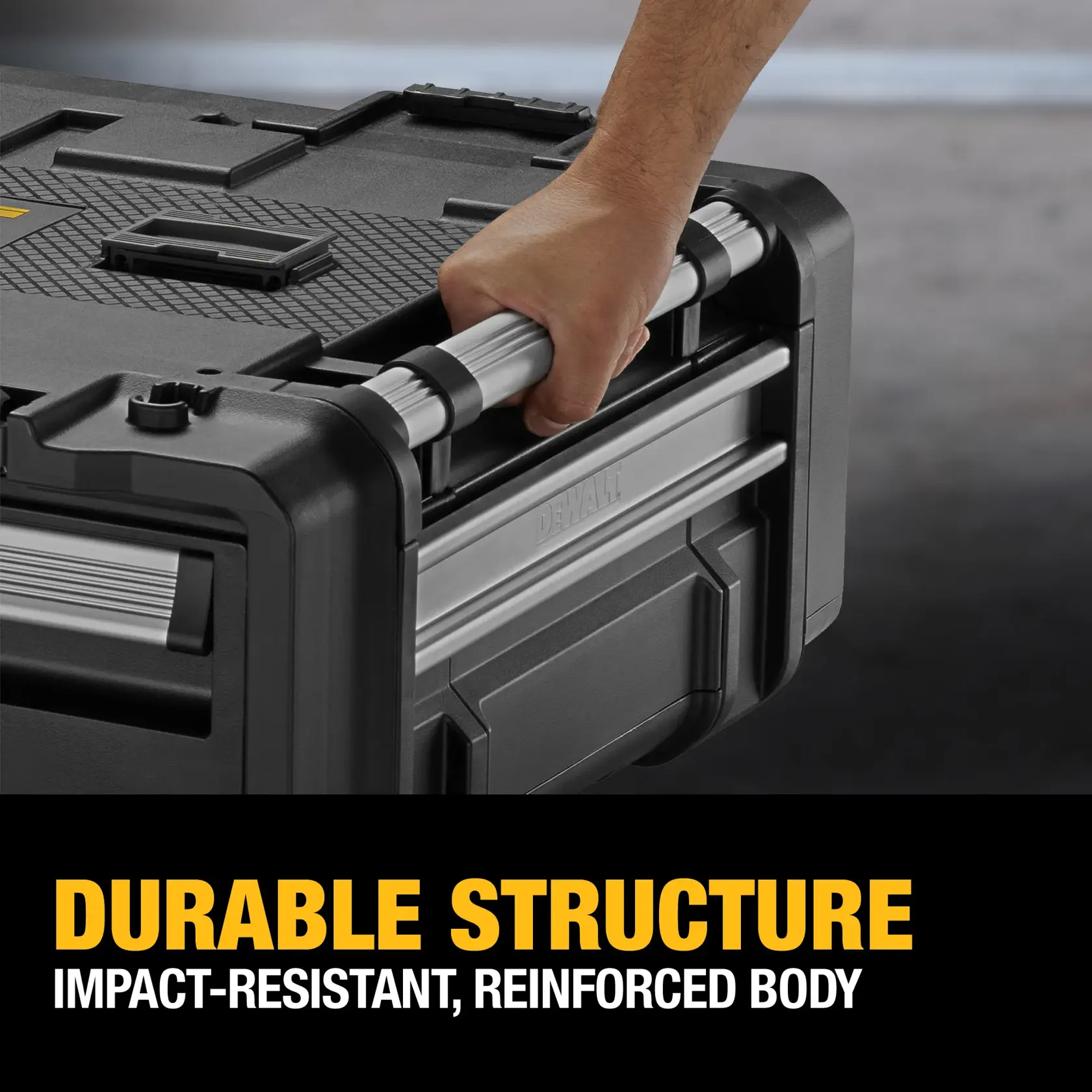 A close-up of a hand holding the metal handle of a DEWALT toolbox, highlighting its impact-resistant, reinforced body. The toolbox is black and sturdy, with text overlay that reads: 'Durable Structure. Impact-resistant, reinforced body.'