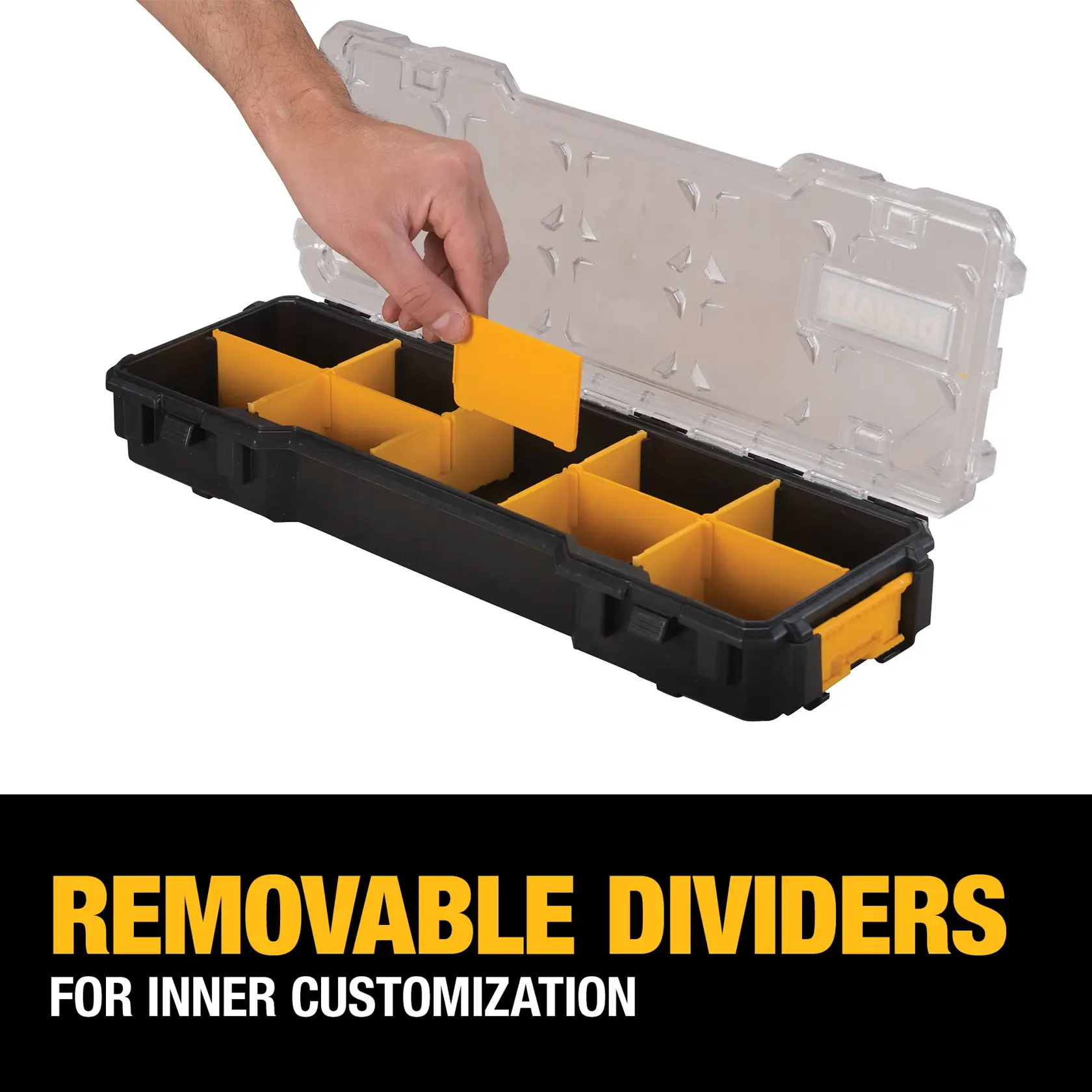 A hand is placing a yellow removable divider into a black DEWALT tool organizer with a transparent lid. The organizer contains several yellow dividers for customizable compartments. Text reads: 'Removable dividers for inner customization.'
