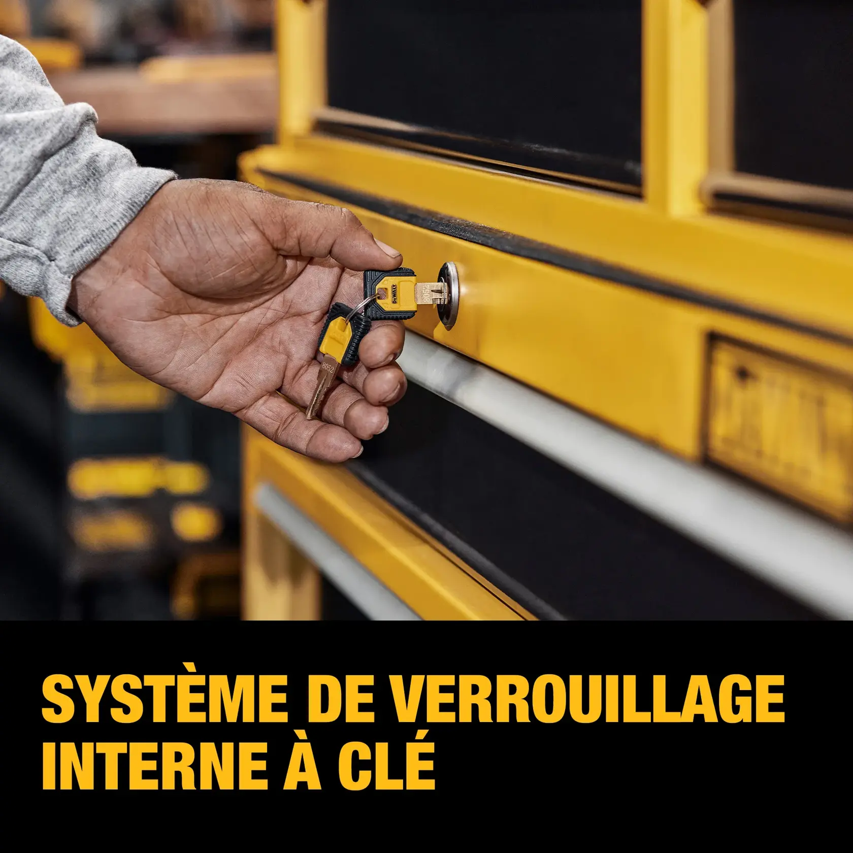 A person inserts a key into the lock of a yellow and black tool storage unit. The foreground features the words 'INTERNAL KEYED LOCKING SYSTEM' in bold yellow text.