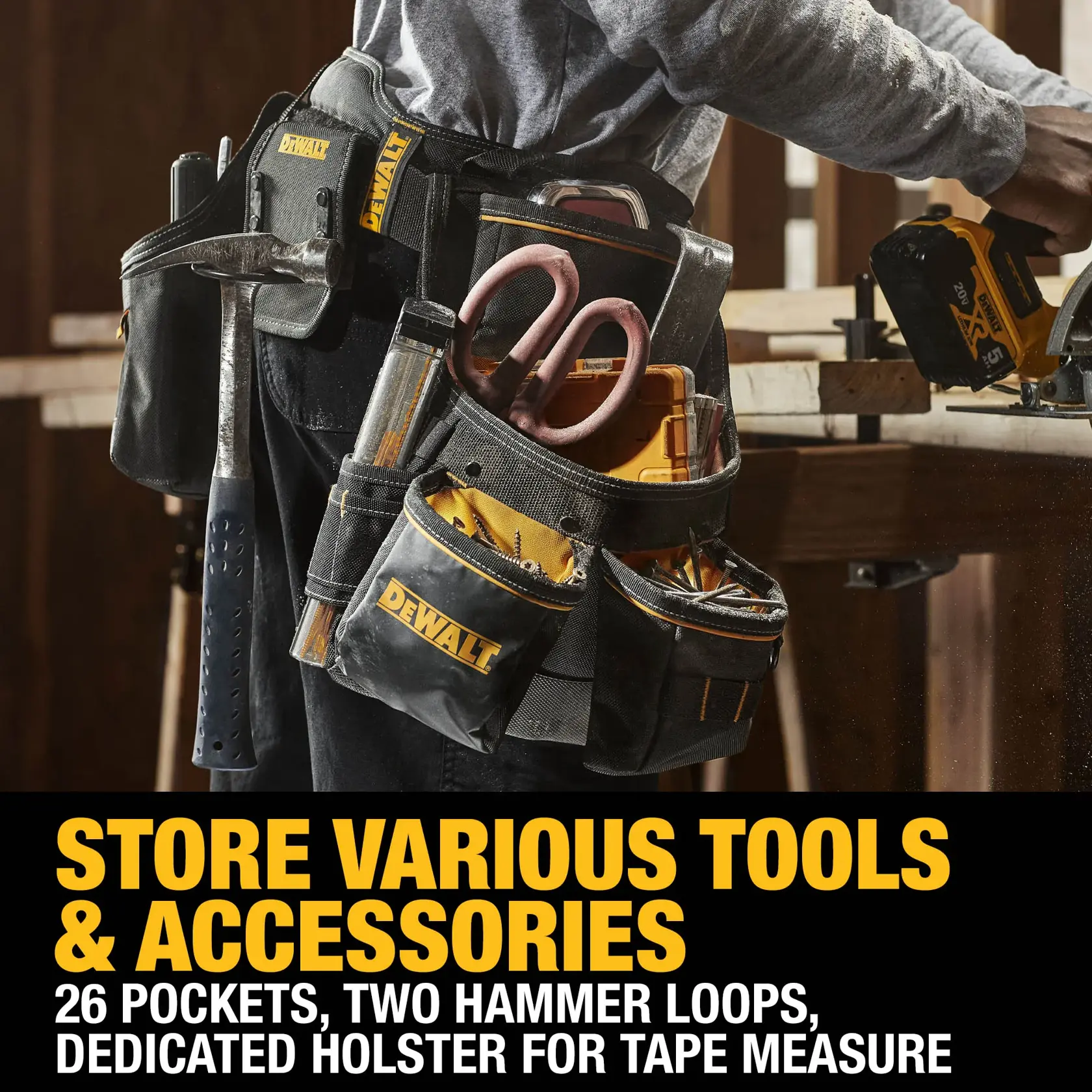 A close-up of a person wearing a DEWALT branded tool belt with multiple pockets containing various tools such as scissors, a hammer, tape, and other accessories. The image highlights the belt's features including 26 pockets, two hammer loops, and a dedicated holster for a tape measure. There is text on the image that says: 'STORE VARIOUS TOOLS & ACCESSORIES. 26 pockets, two hammer loops, dedicated holster for tape measure.'