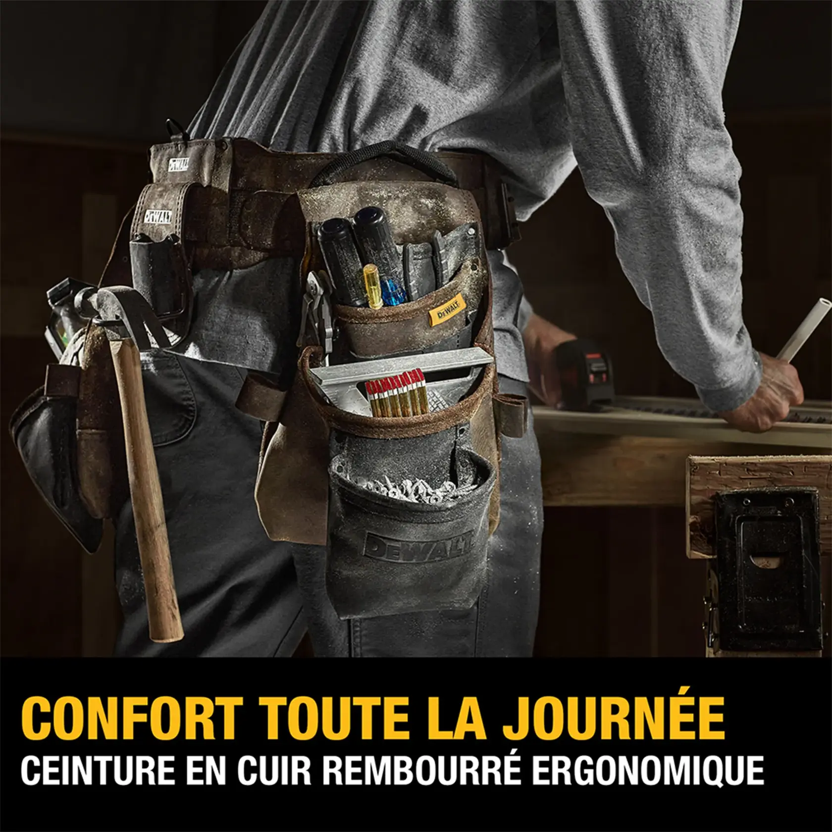 A person wearing a DEWALT ergonomic, padded leather tool belt filled with various tools and accessories, standing at a workbench. Text on the image reads: 'ALL DAY COMFORT - ERGONOMIC, PADDED LEATHER BELT.'